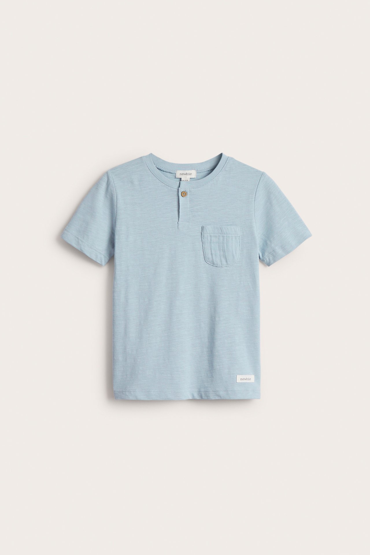 Vorderansicht: Hellblaues Kinder-T-Shirt aus Slub-Jersey mit kurzen Ärmeln, Brusttasche und einem Knopf.