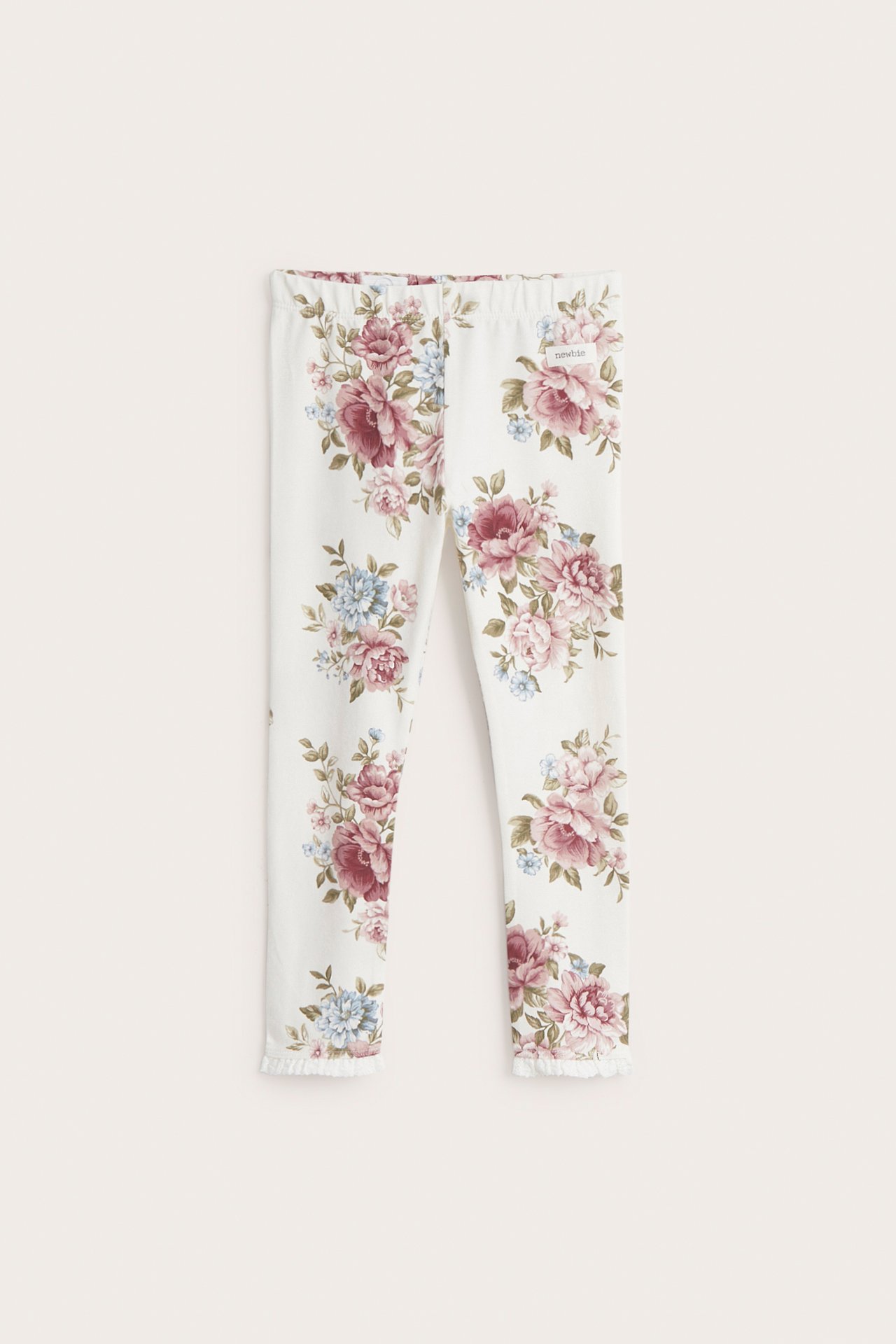 Front view of off-white kid's cotton jersey leggings with a pink and blue floral print and lace trim.