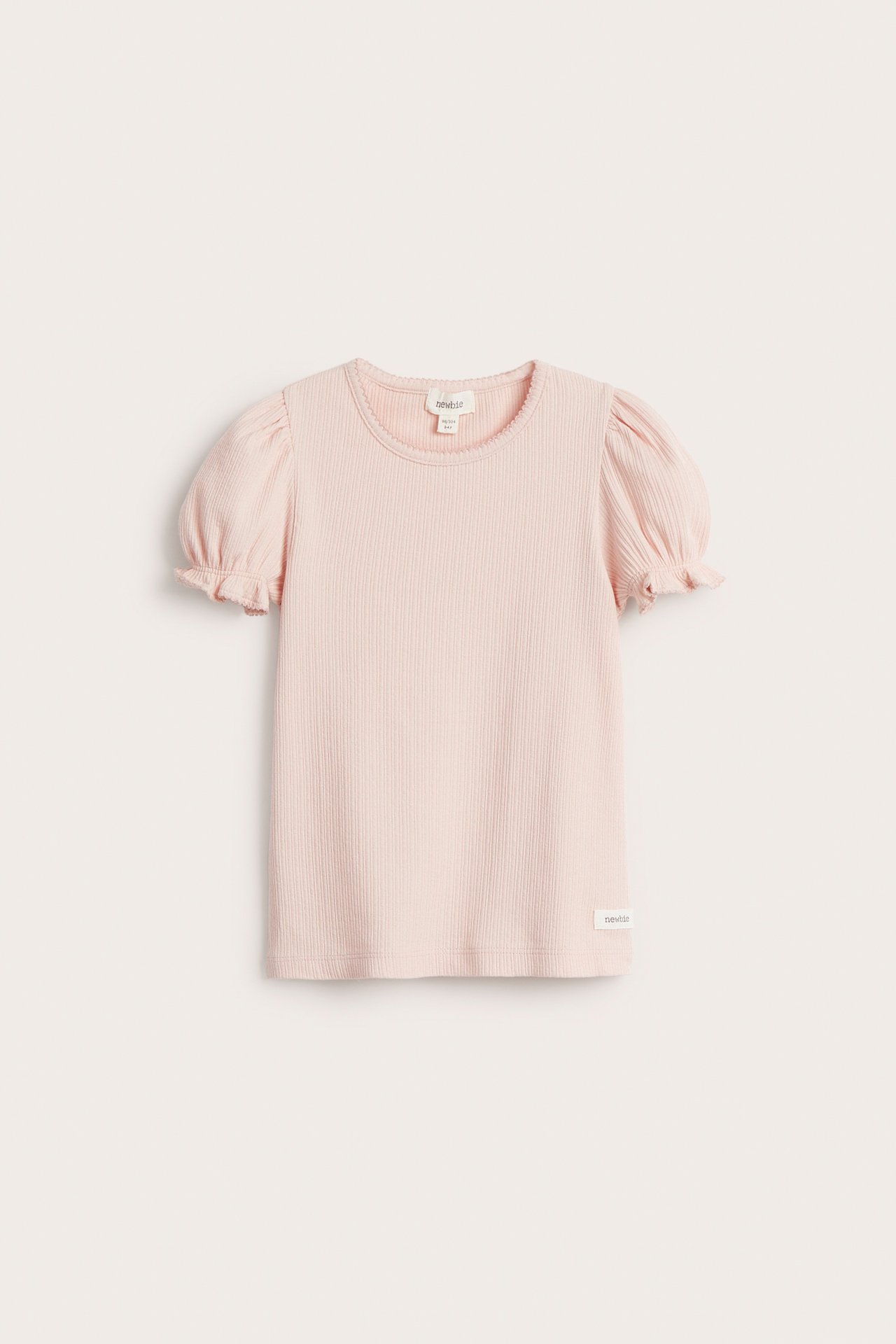 Front view of a light pink ribbed jersey kid's top with short puff sleeves and picot trim.