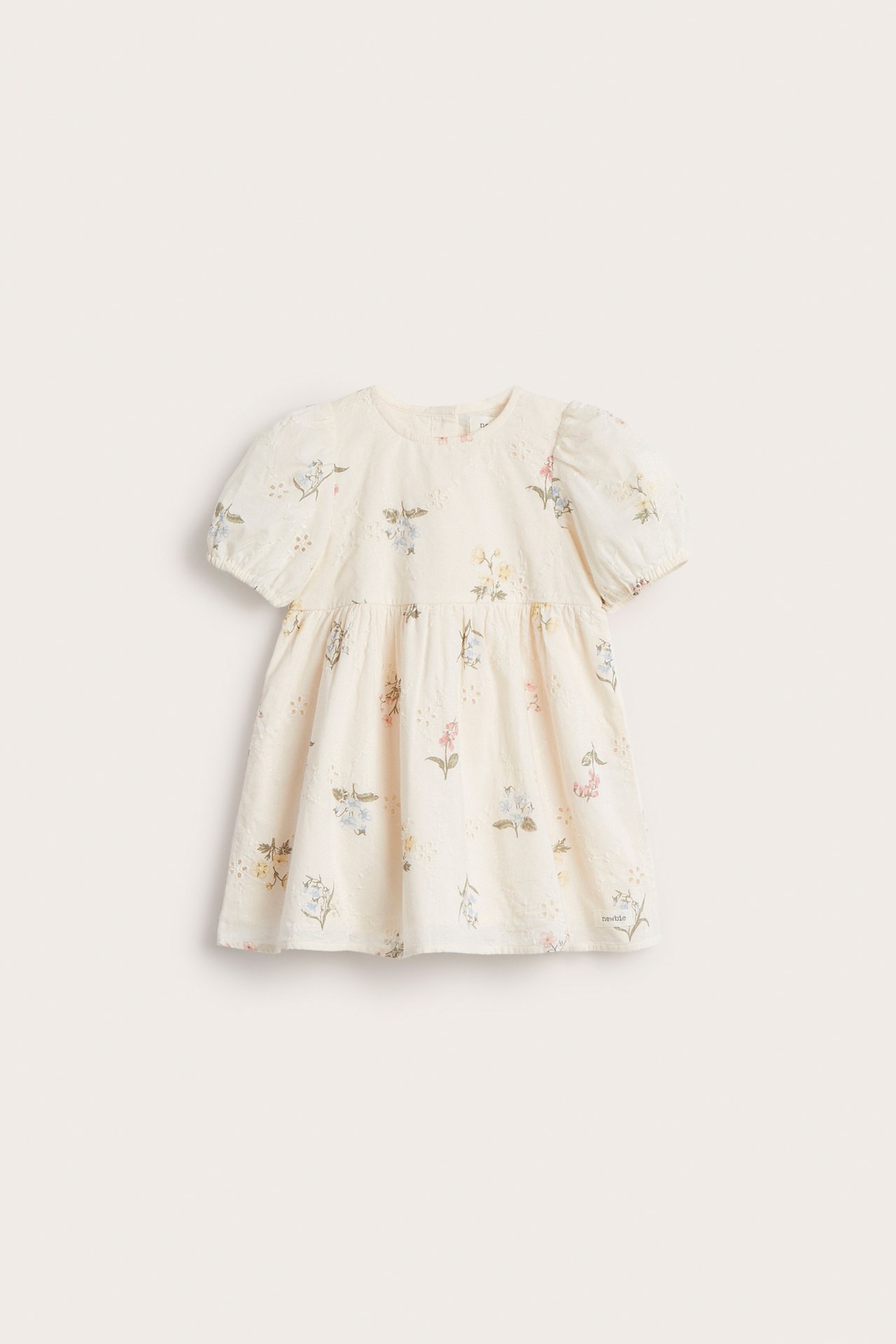 Vorderansicht: Kinder-Kleid in Offwhite mit Broderie Anglaise, Blumenmuster und kurzen Puffärmeln.