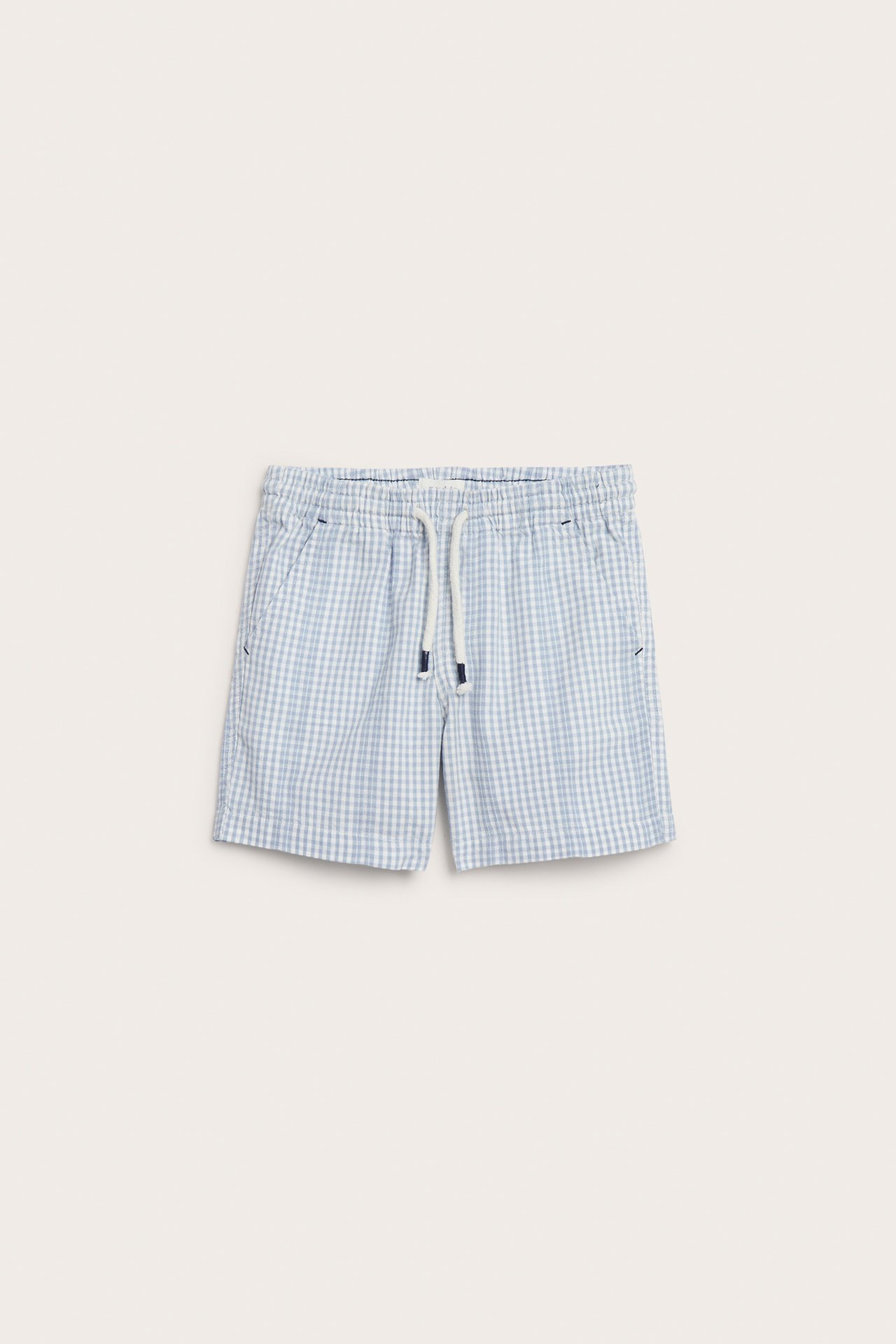 Front view of kid's light blue and off-white checked cotton shorts with drawstring waist and side pockets.