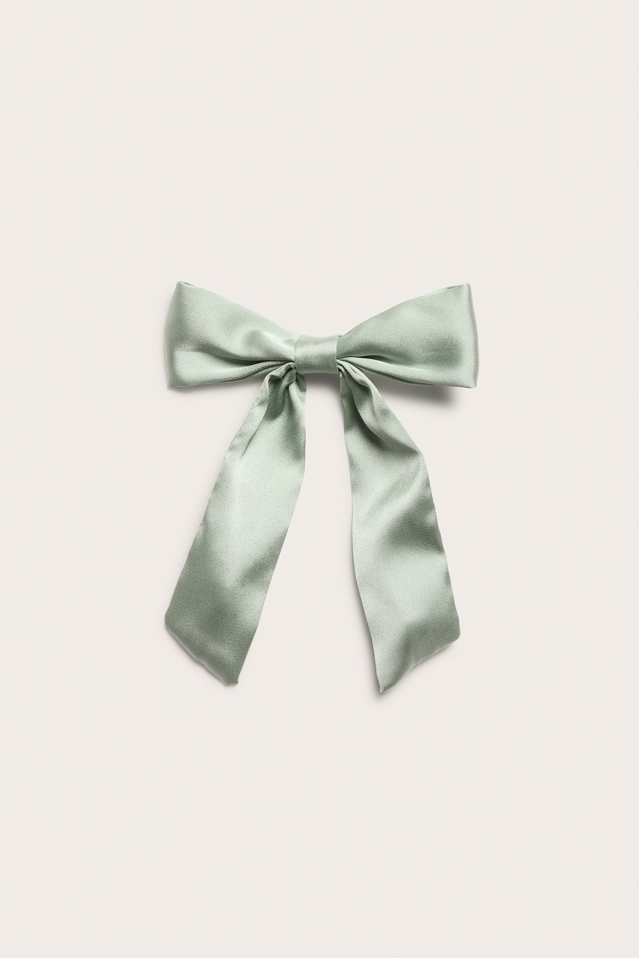 Front view of a light green satin bow hair clip with two long tails.