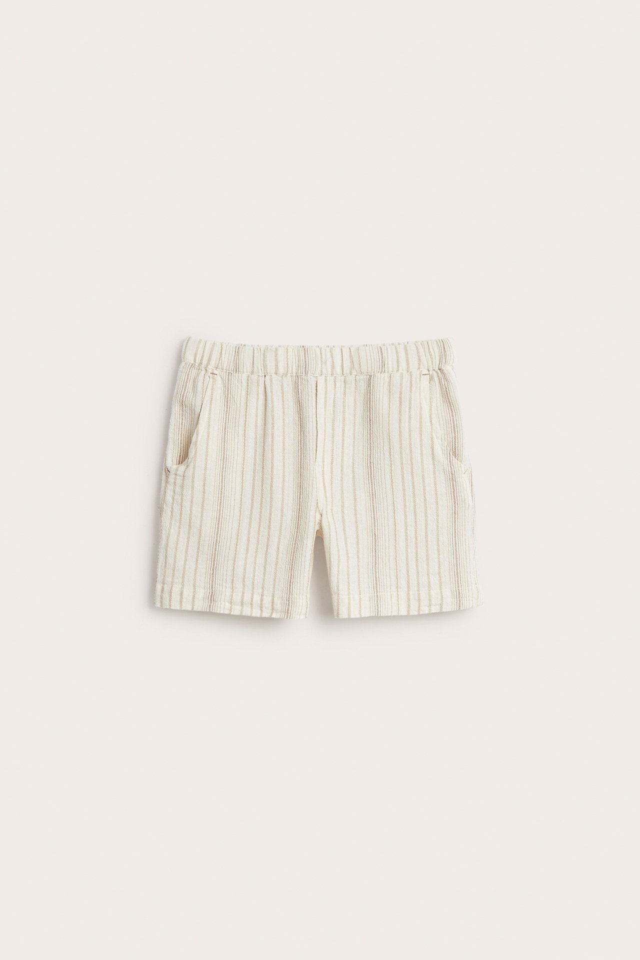 Front view of off-white striped cotton shorts with an elastic waist and side pockets.
