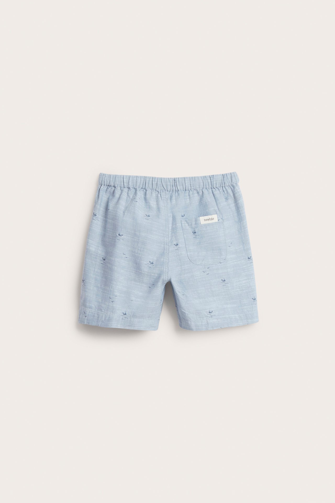 Rückansicht von hellblauen Kinder-Chambray-Shorts aus Baumwolle mit Gummizug, Walmuster und einer Gesäßtasche.