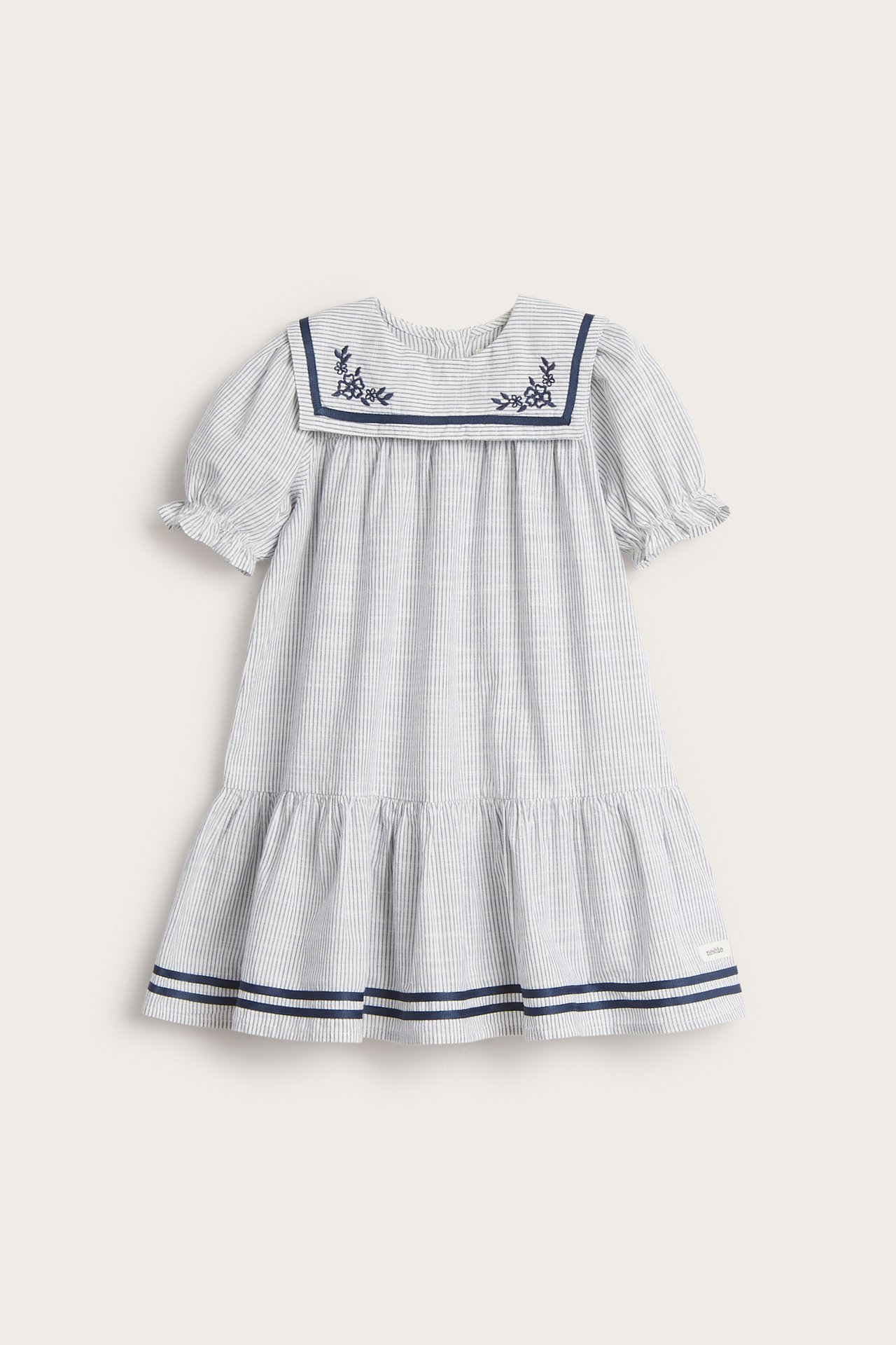 Vorderansicht: Gestreiftes Baumwollkleid für Kinder in Off-White mit besticktem Matrosenkragen, Puffärmeln und blauem Stufenrocksaum.