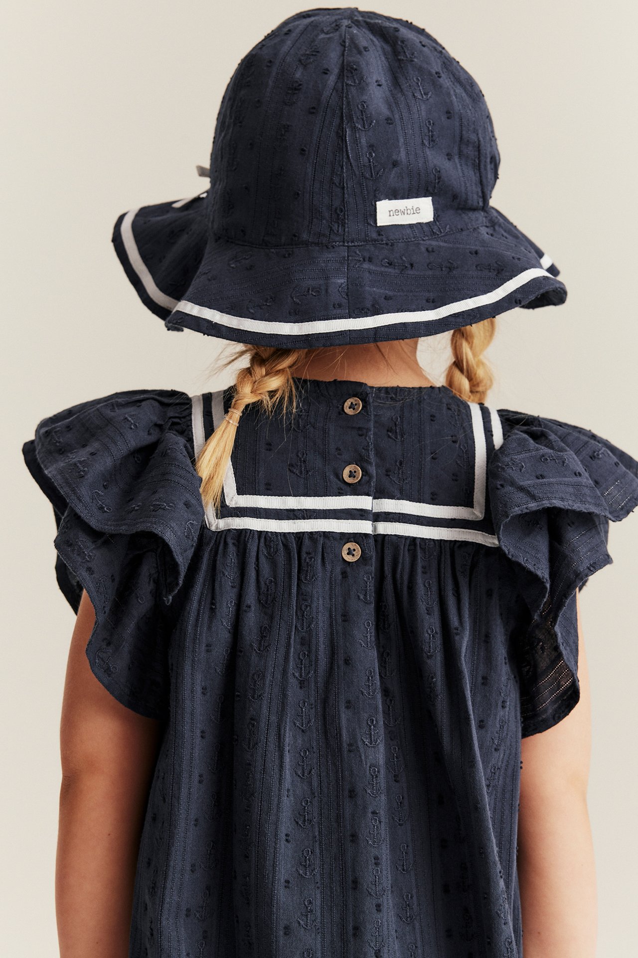 Kinder-Dunkelblaues Kleid mit Ankermuster, Rüschenärmeln, Matrosenkragen und passendem Fischerhut.