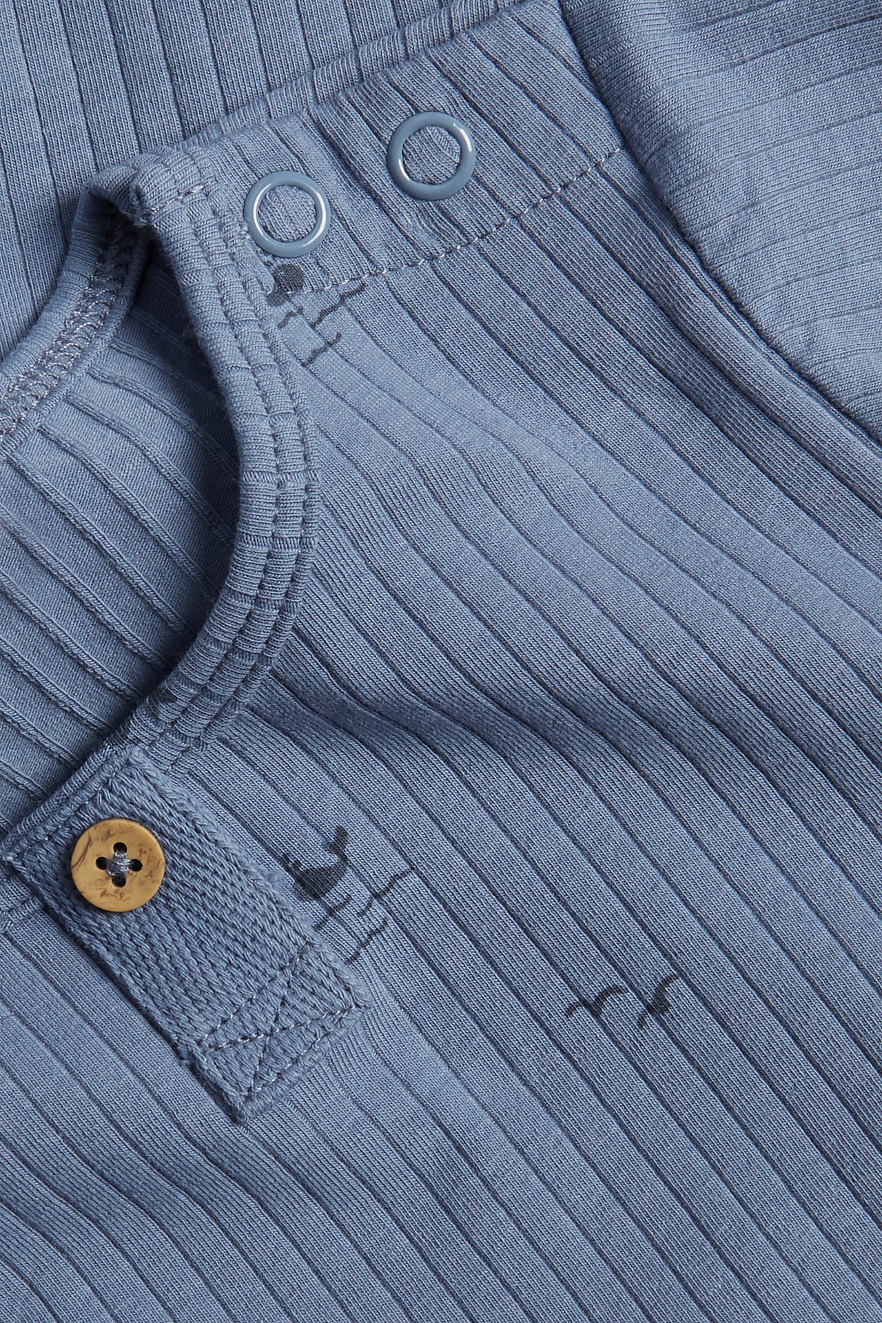 Nahaufnahme: Blauer gerippter kurzärmeliger Baby-Body mit Meeresmuster, Druckknöpfen und Zierknopf.