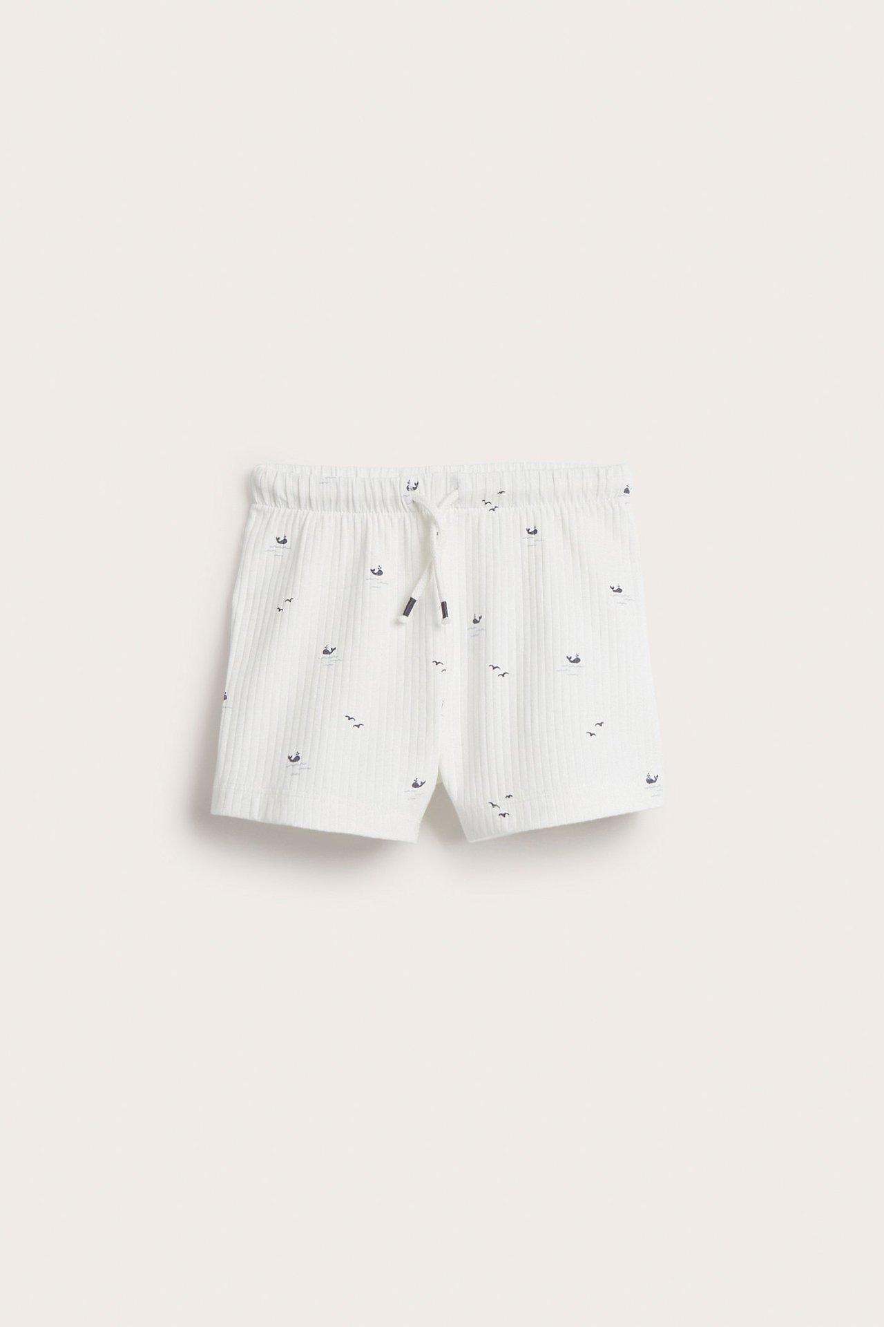Front view of kid's off-white ribbed shorts with a sea animal pattern and drawstring waist.