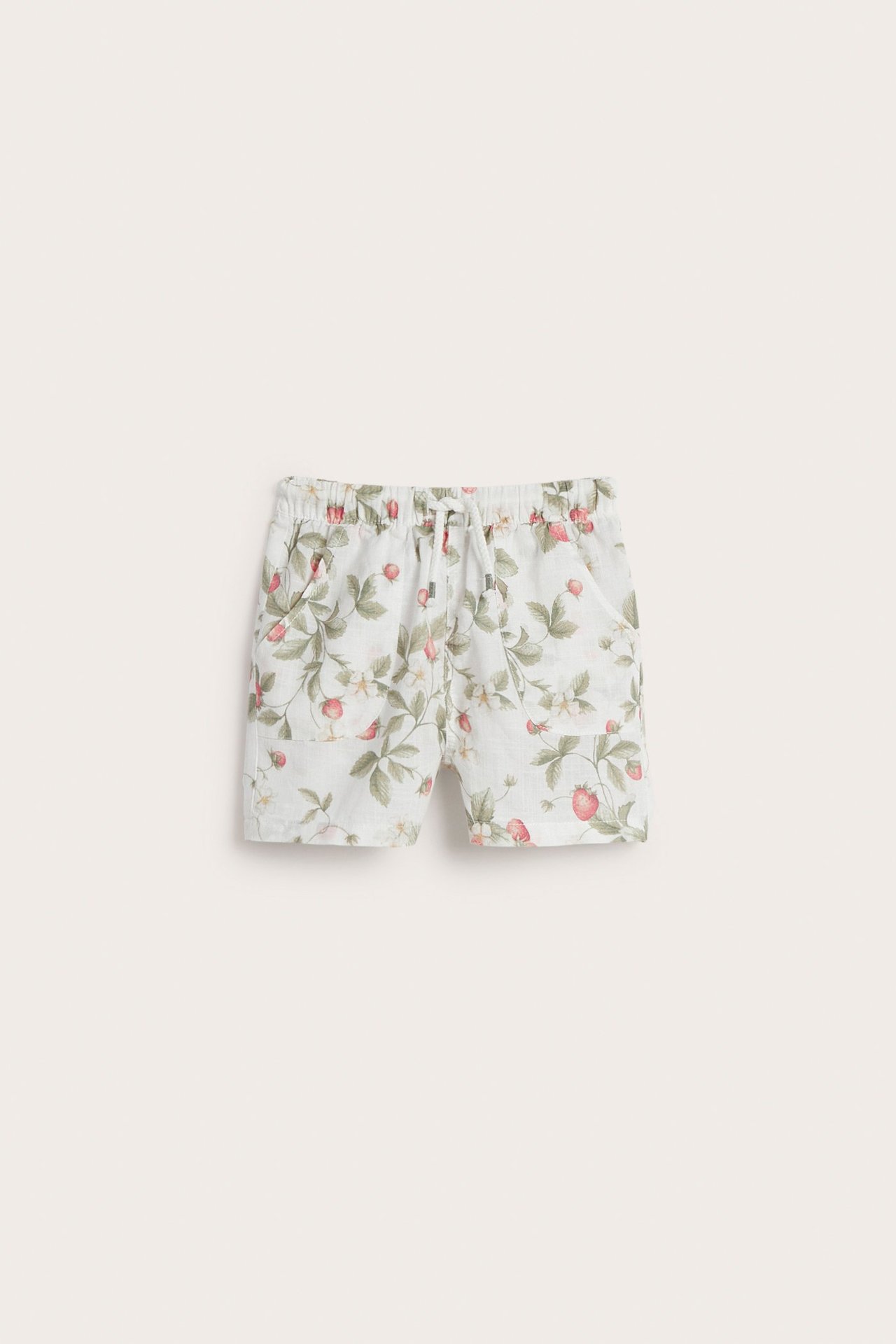 Vorderansicht von cremeweißen Baumwollshorts mit Erdbeermuster, Gummizugbund, Kordelzug und aufgesetzten Taschen.