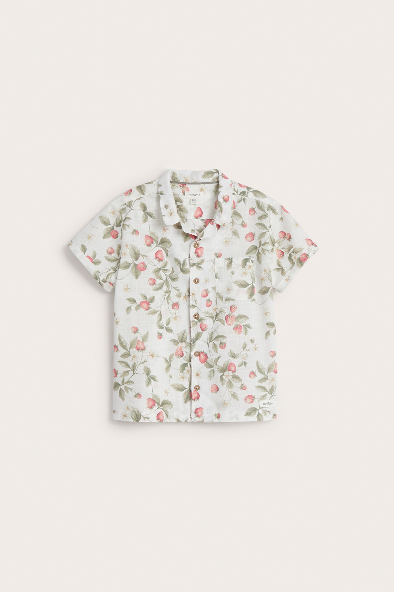 Front view: off-white kid's short-sleeved cotton shirt with red strawberry pattern, collar, buttons, and pocket.
