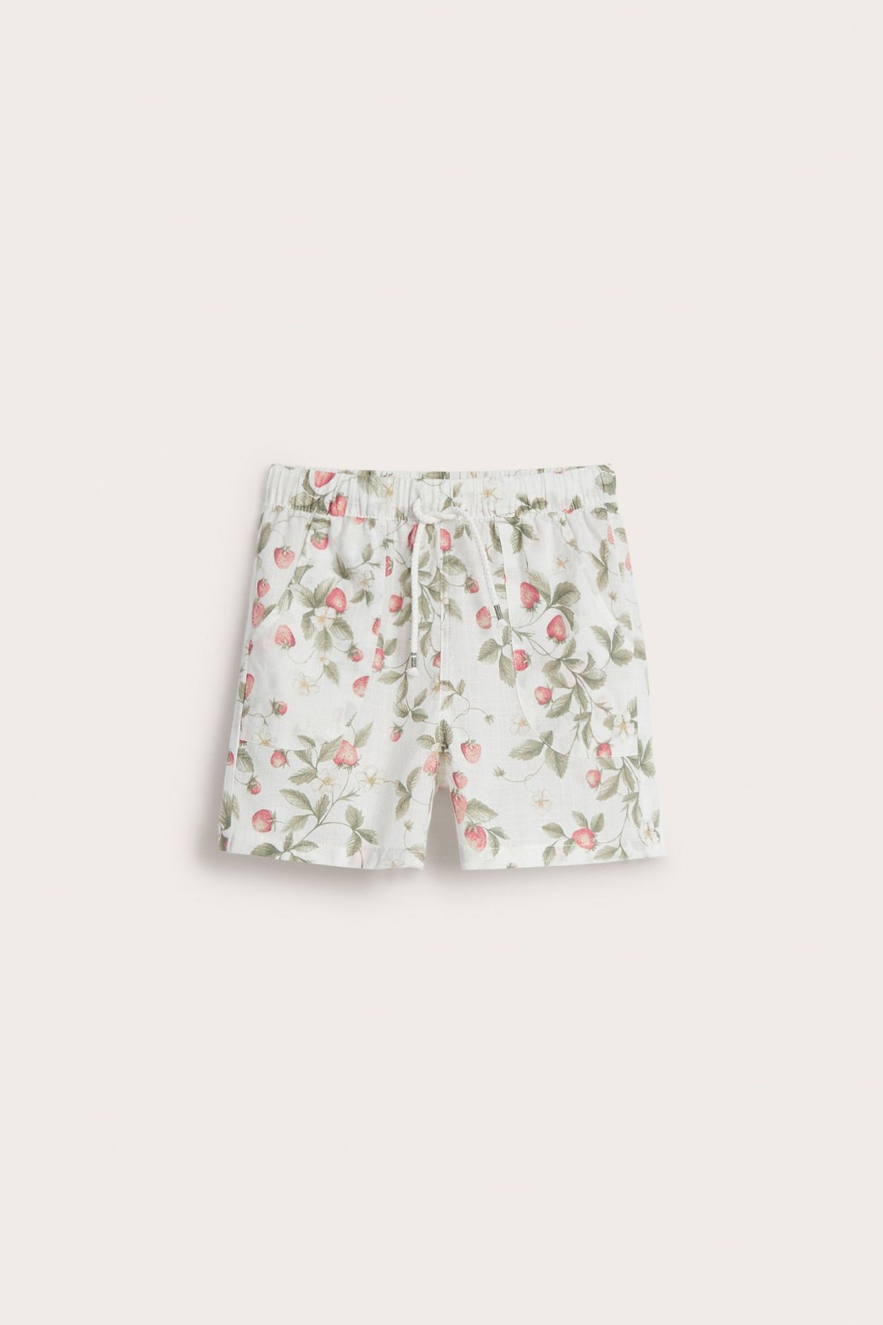 Vorderansicht von cremeweißen Baumwollshorts mit rotem Erdbeermuster, elastischem Bund und Kordelzug.