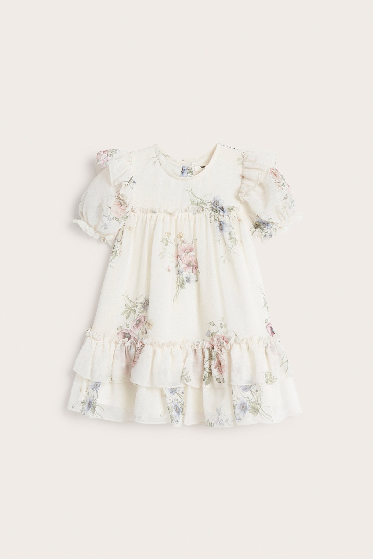 Front view of an off-white floral chiffon kid's dress with puff sleeves and ruffled tiers.