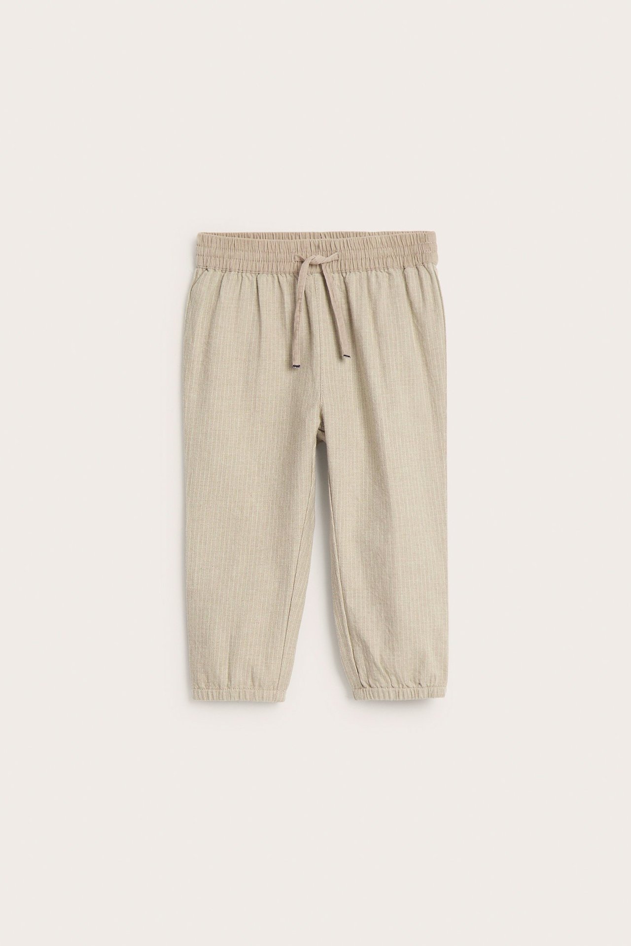 Vorderansicht von gestreiften Kinderhosen in Beige Melange aus Baumwolle mit elastischem Kordelzugbund und Bündchen.