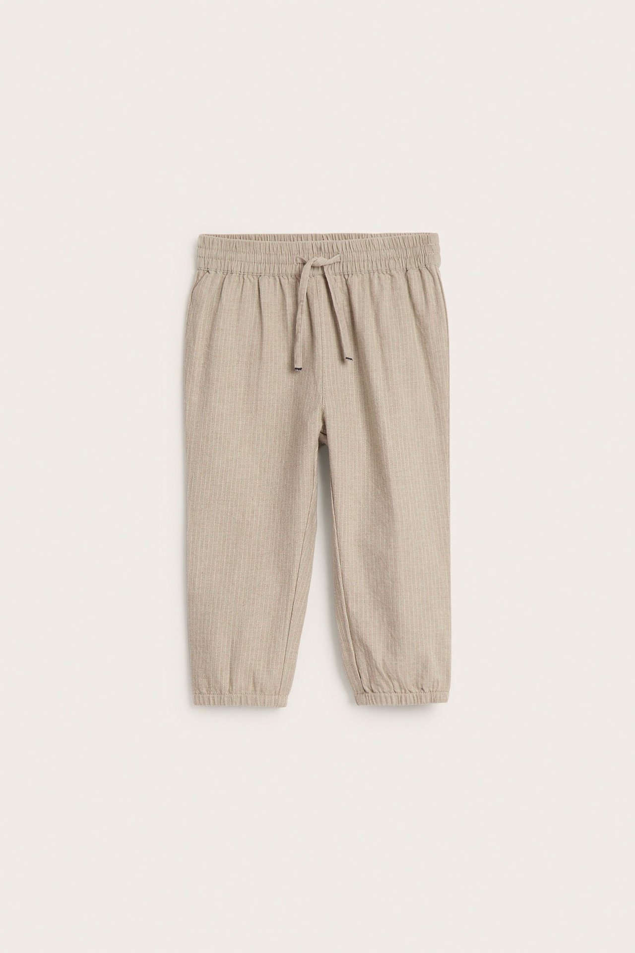 Front view of kid's beige melange striped woven pants with an elastic waist, drawstring, and elastic cuffs.