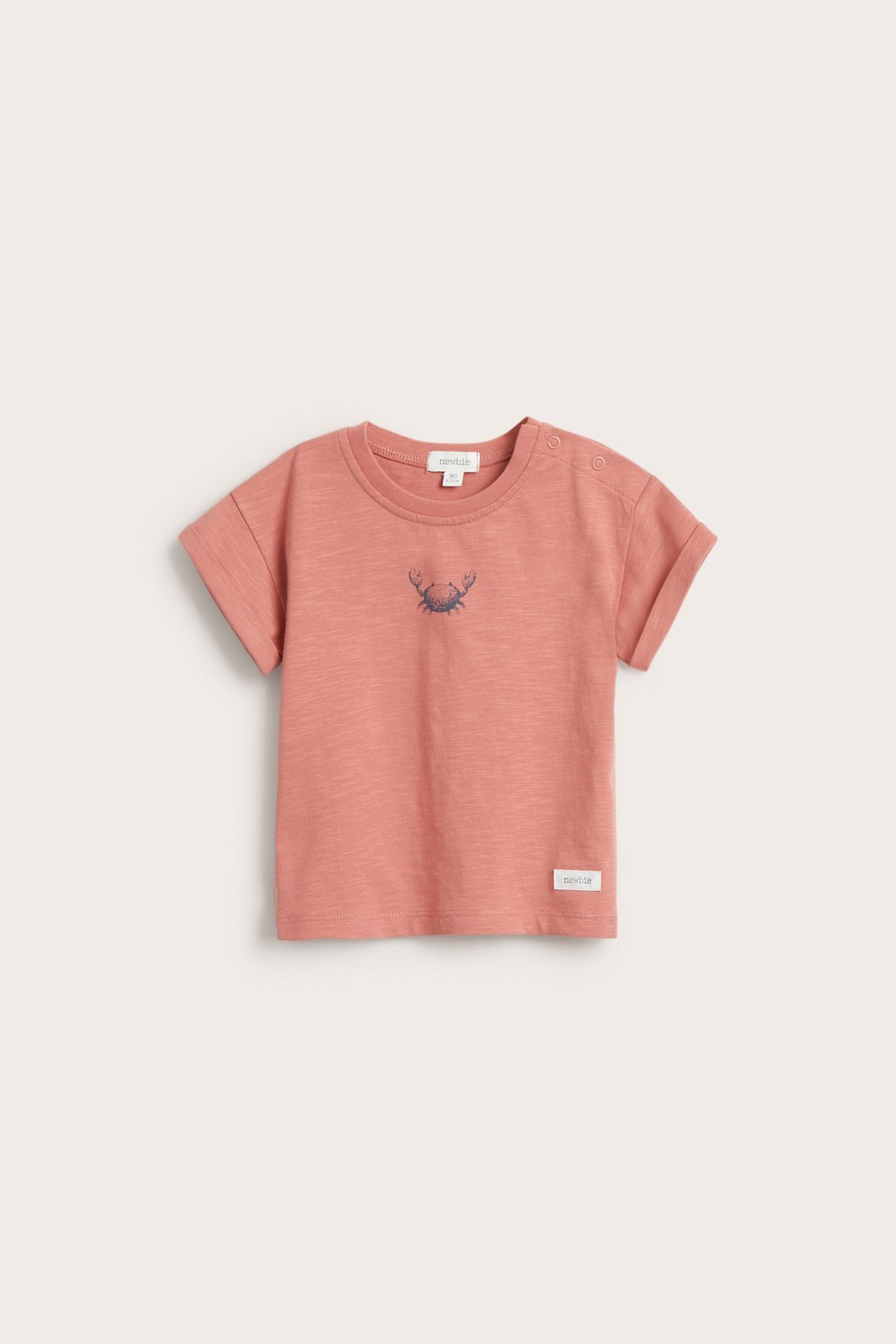 Vorderansicht: rosa Baby-T-Shirt aus Baumwolle mit Krabbendruck und Schulter-Druckknöpfen.