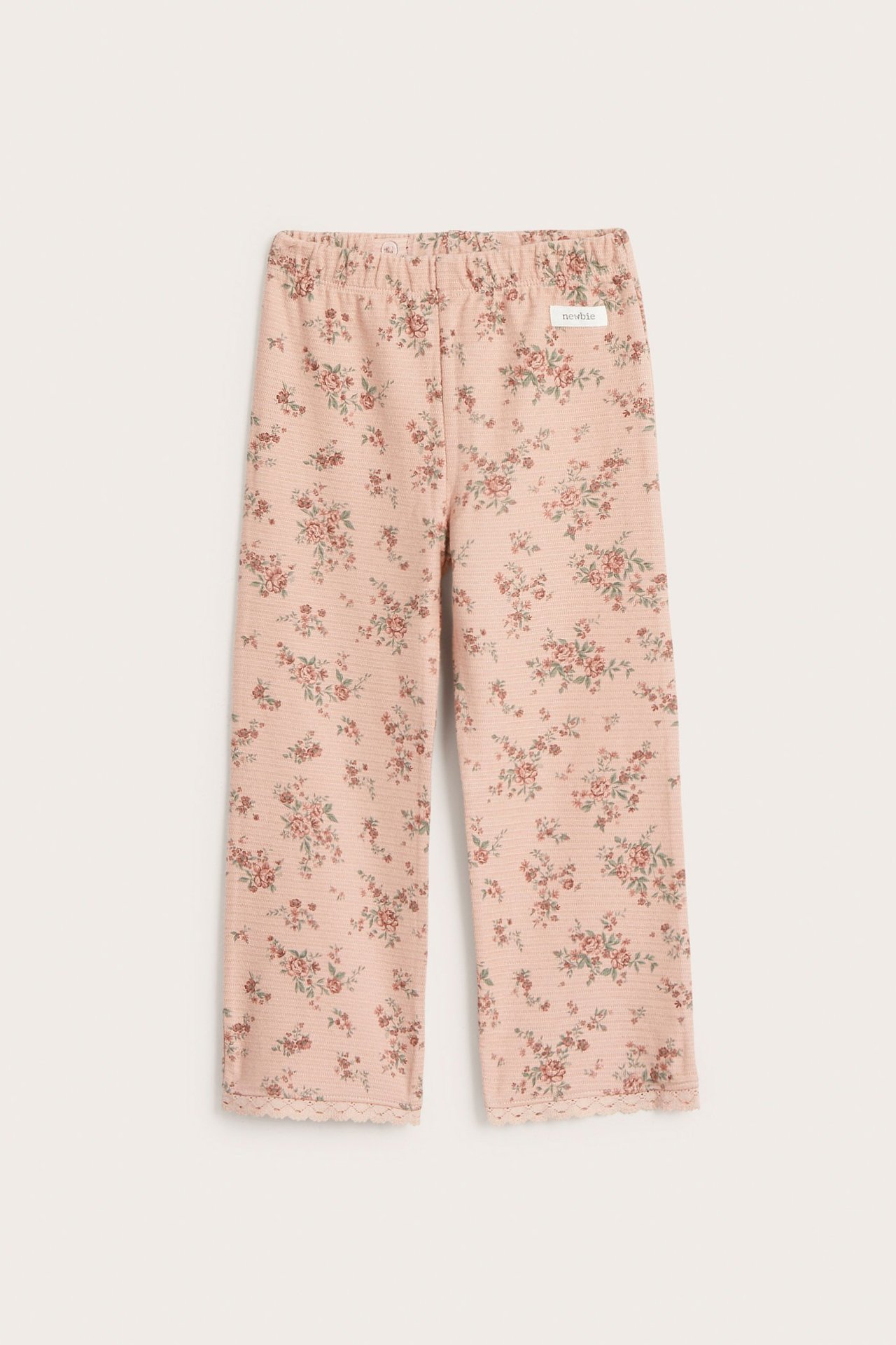 Vorderansicht rosa ausgestellter Baby-Leggings aus Strukturjersey mit kleinem Blumenmuster und Spitzenbesatz.