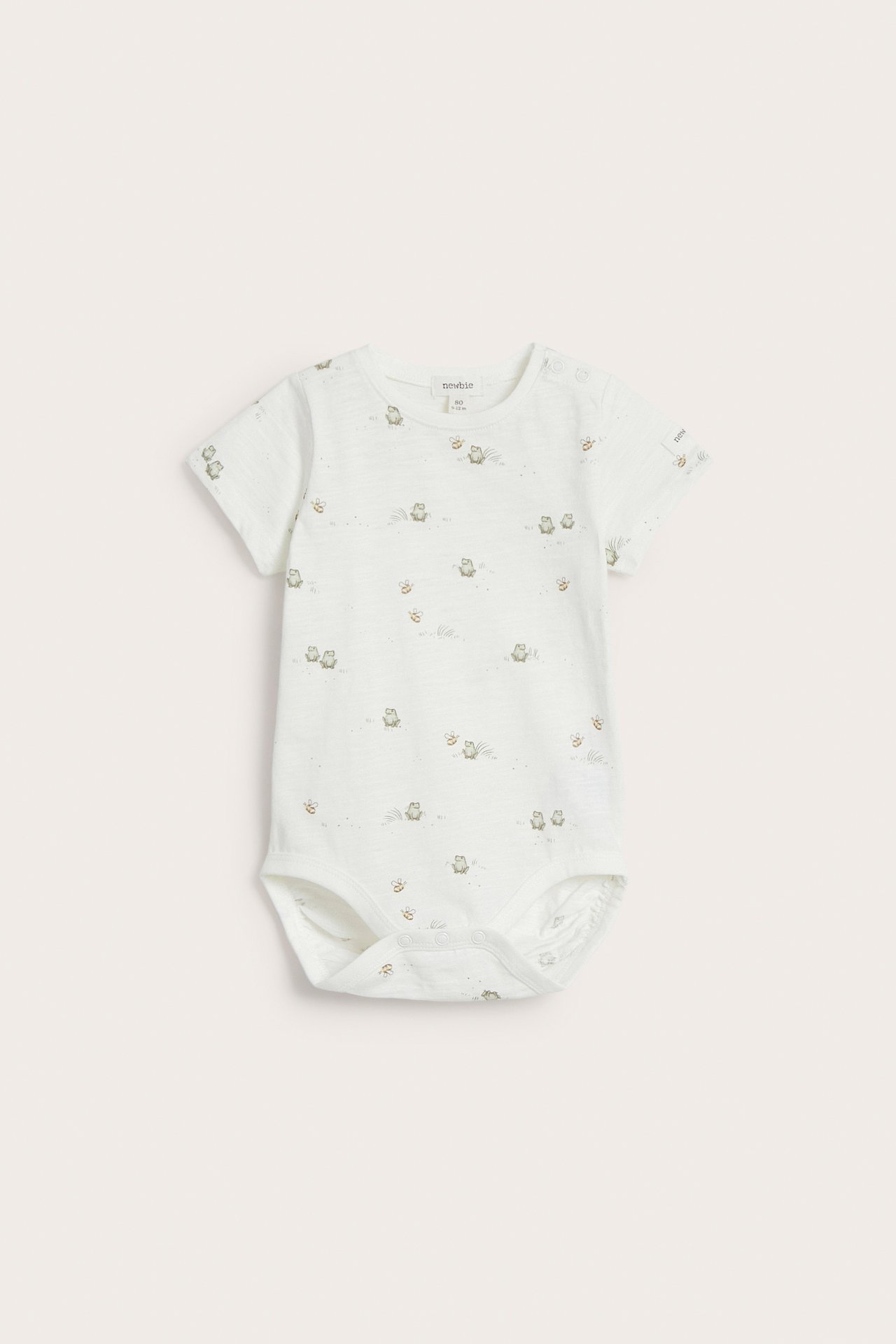 Front view of an off-white baby short-sleeved cotton bodysuit with a frog print and snap buttons.