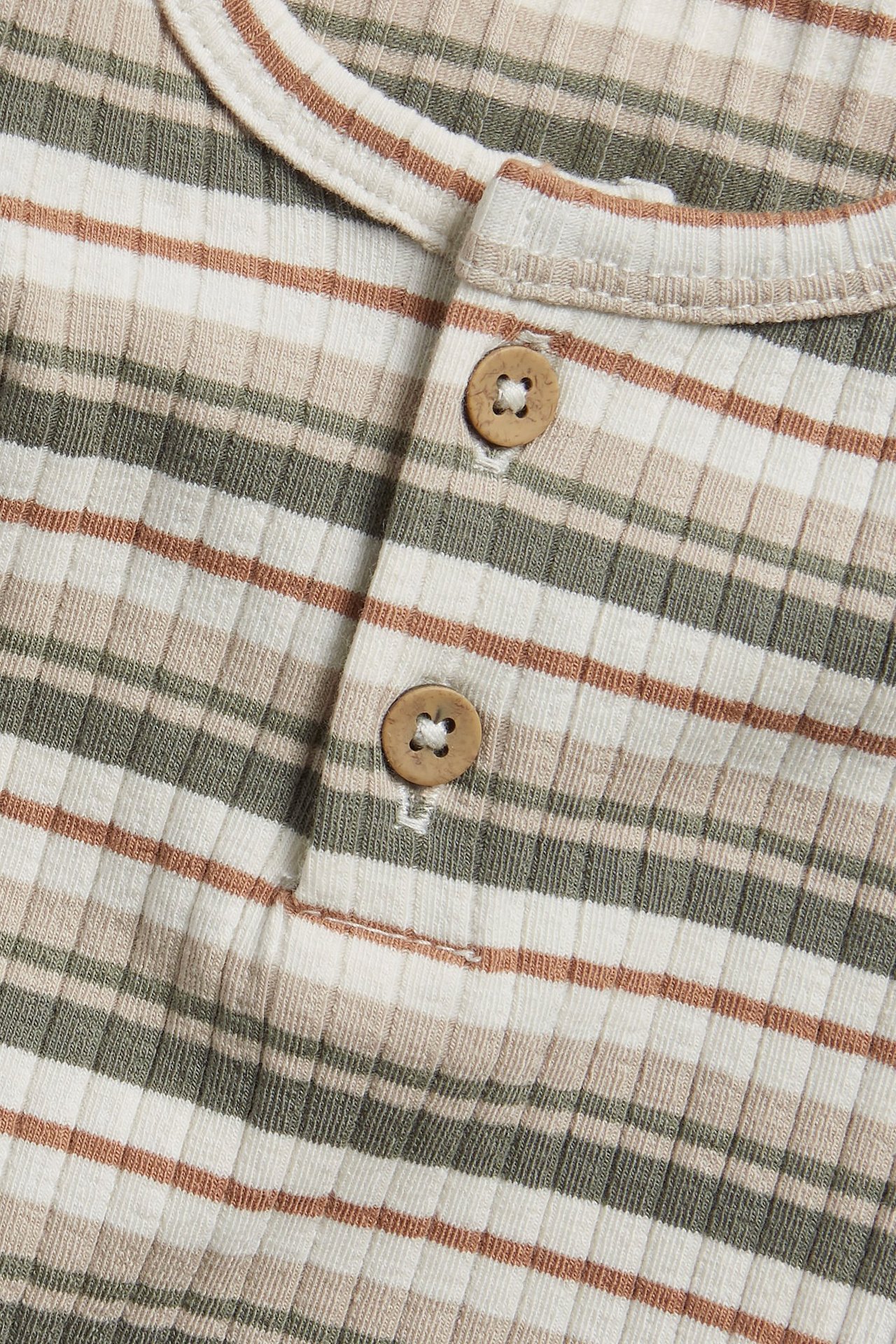 Nahaufnahme: Off-white gerippter Langarm-Body mit braunen und grünen Streifen, Holzknöpfen.