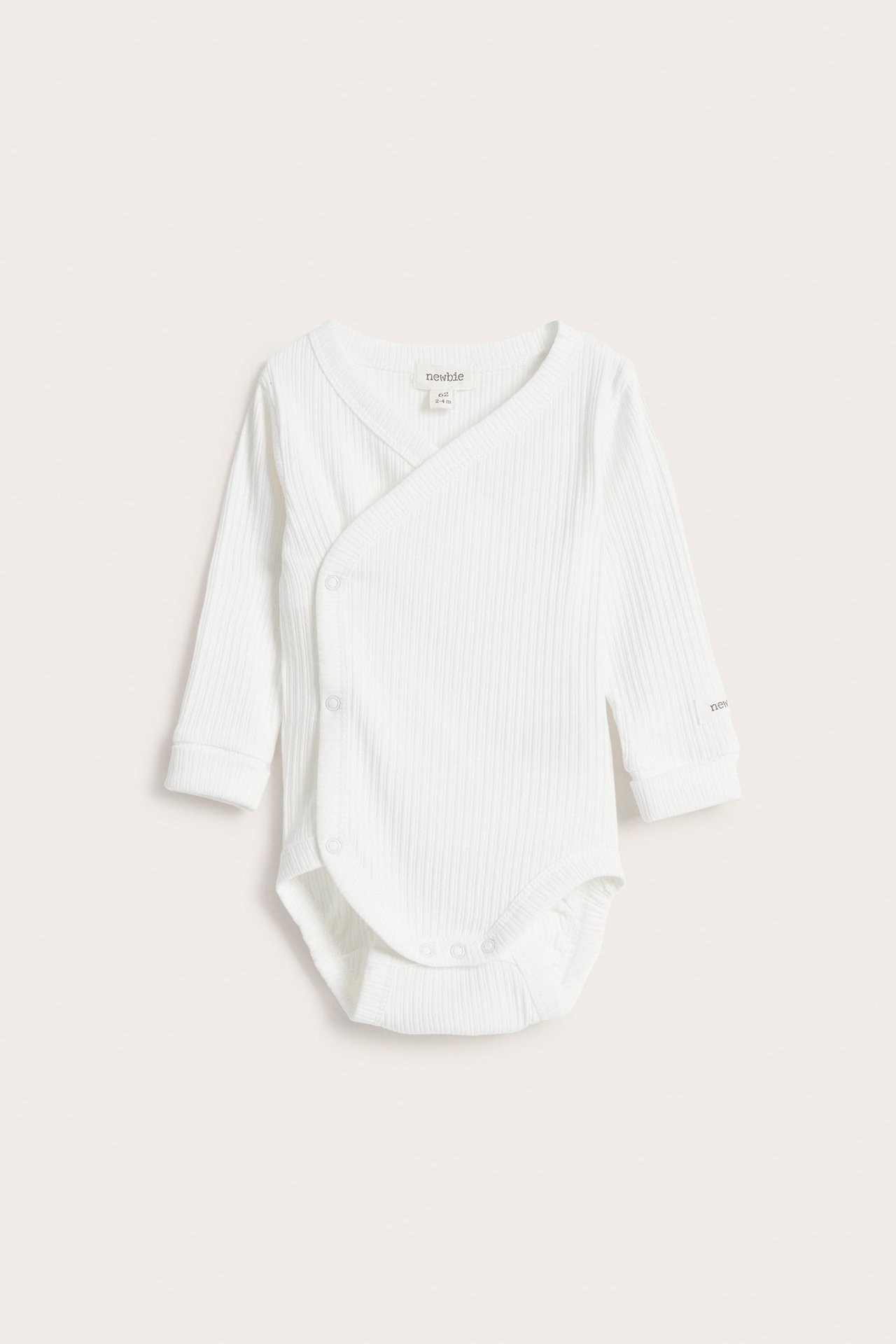 Front view of an off-white ribbed baby wrap bodysuit with long sleeves and snap buttons.