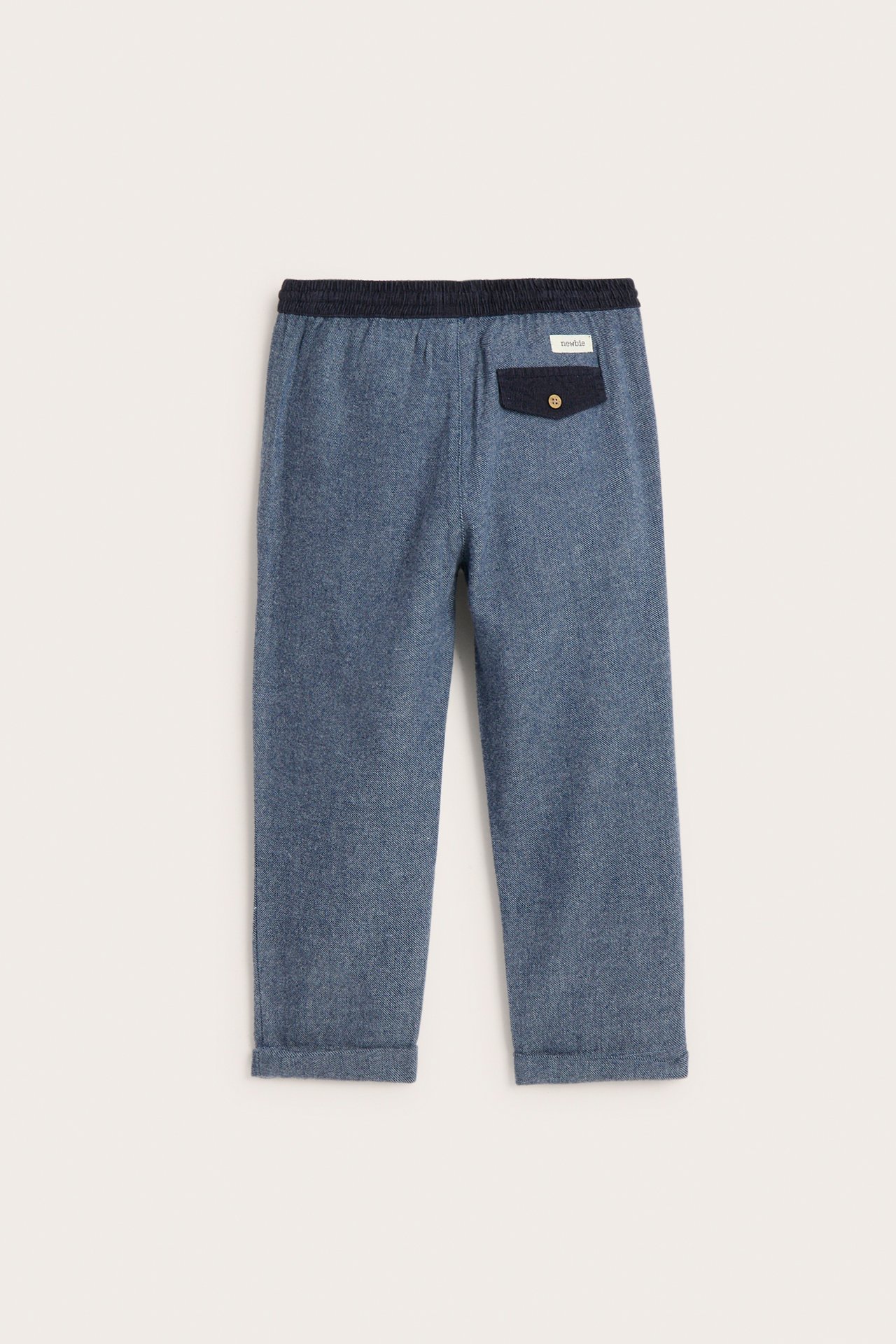Back view of kid's dark blue woven twill pants with an elastic corduroy waist and buttoned back pocket.