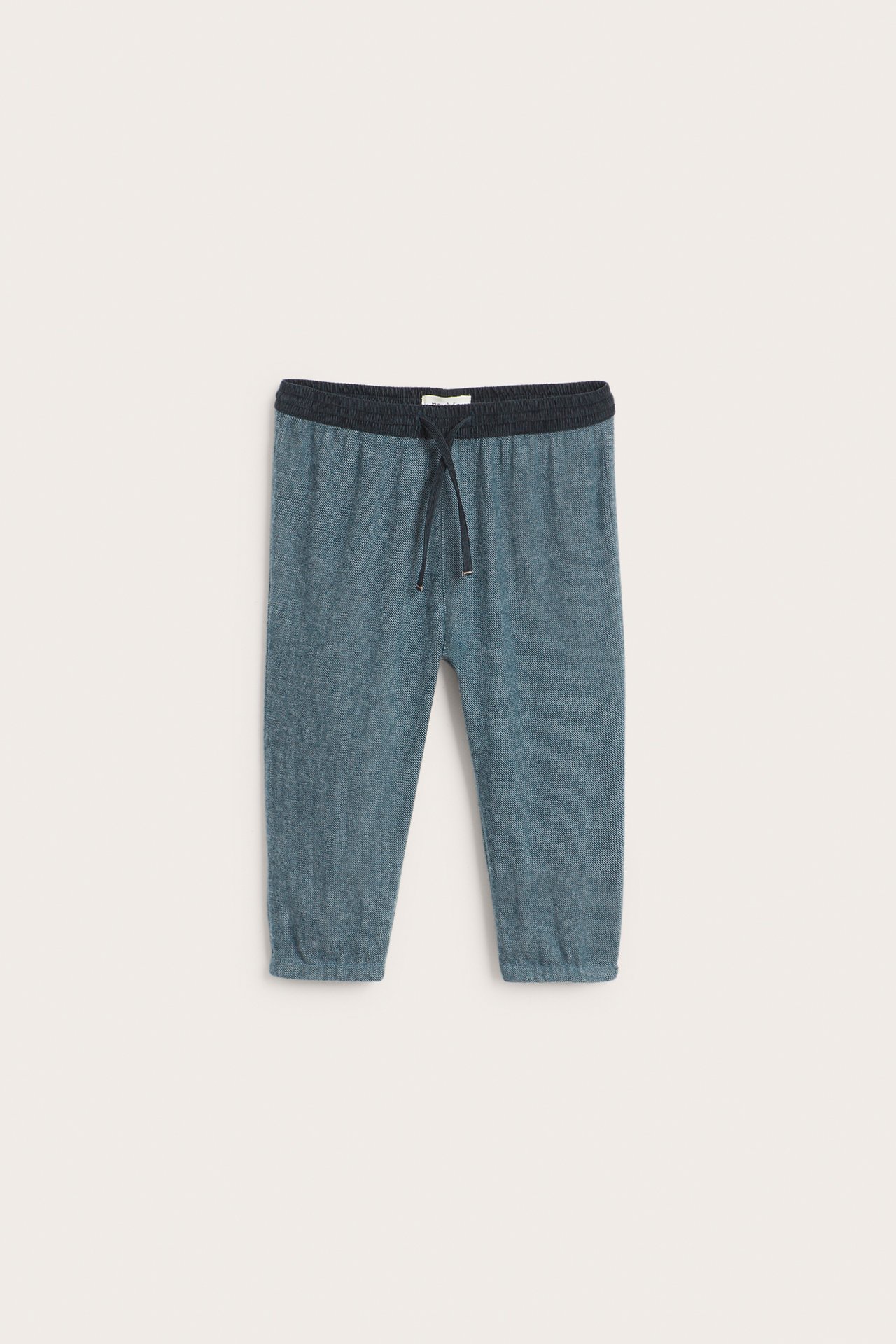 Front view of kid's dark blue woven twill pants with a dark corduroy elastic waist and drawstring.