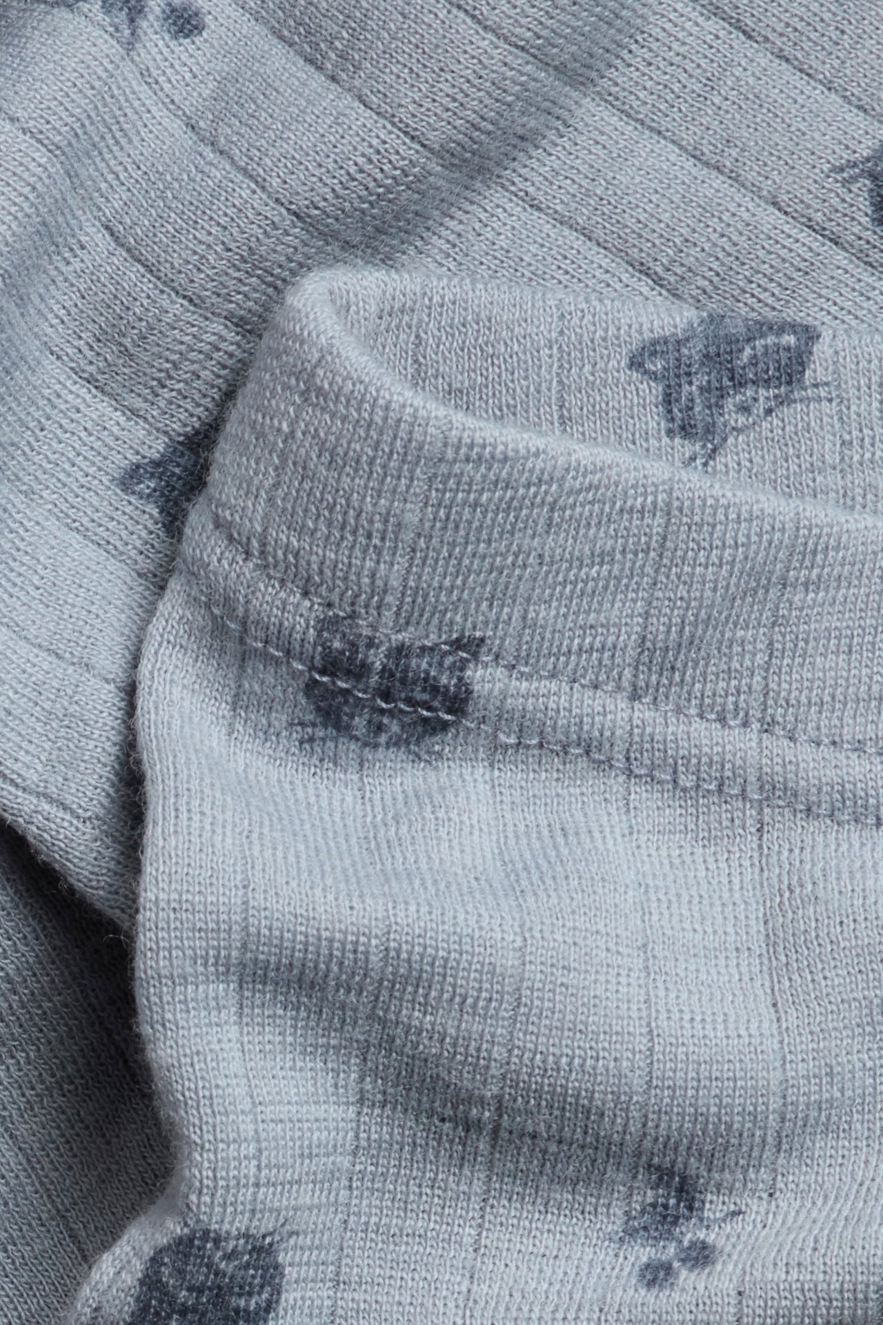 Nahaufnahme von hellblauen gerippten Merinowolle-Leggings mit dunklem Tiermuster und elastischem Bund.
