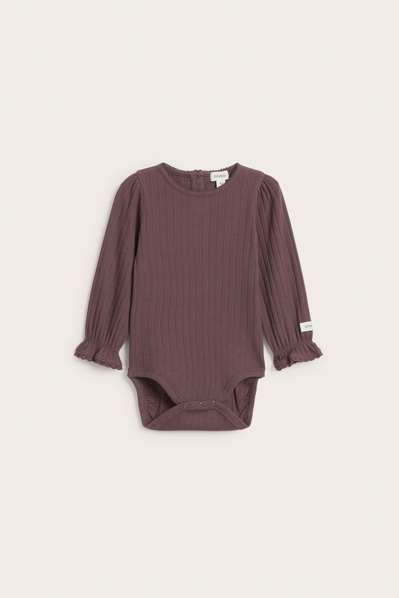 Vorderansicht eines einfarbigen lila gerippten Baby-Bodys aus Baumwolle mit langen Rüschenärmeln und Druckknöpfen.