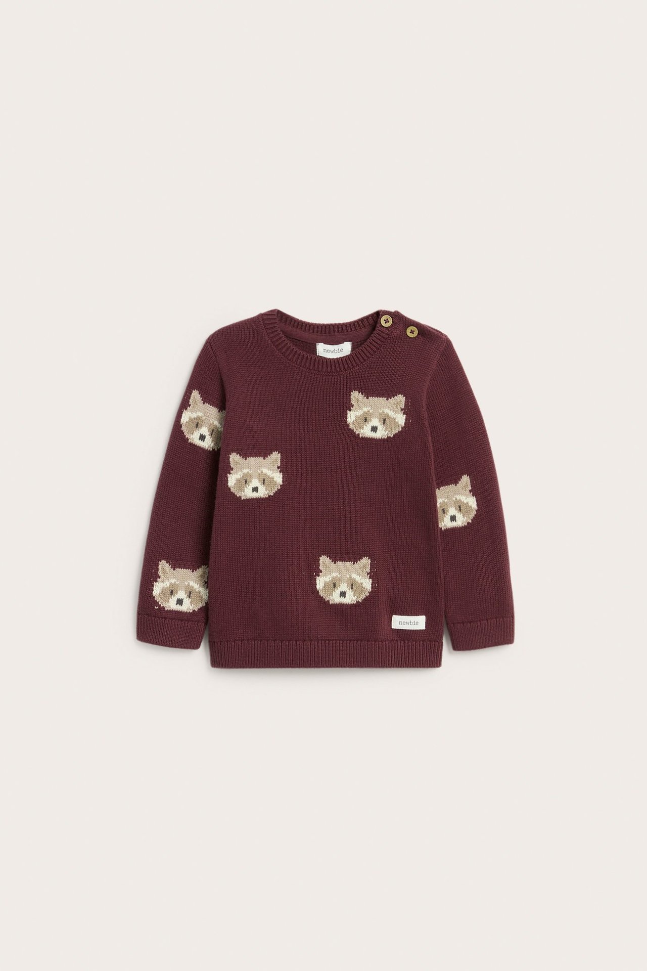 Vorderansicht eines weinroten Baby-Strickpullovers aus Baumwolle mit Jacquard-Waschbärmuster und Schulterknöpfen.