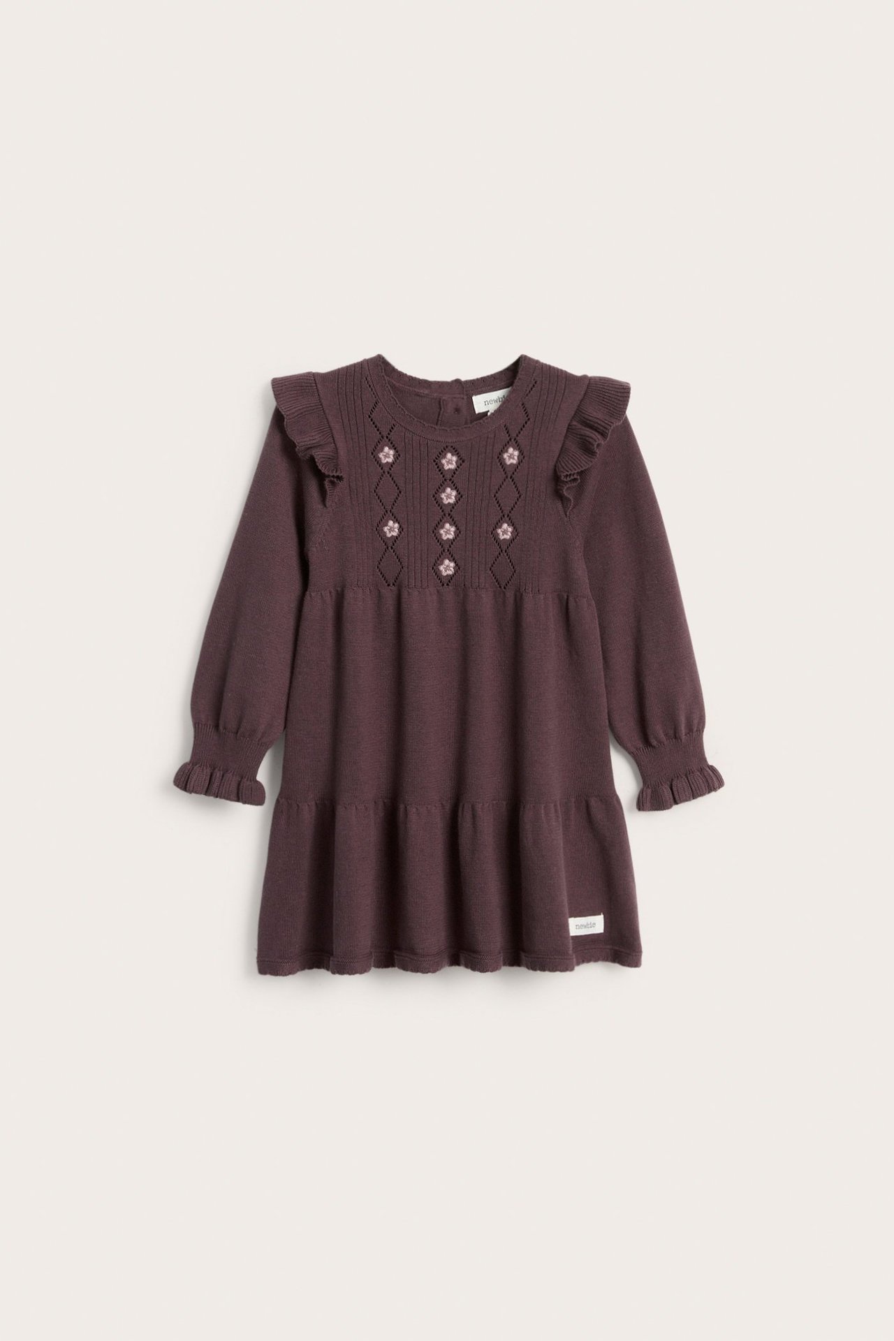 Vorderansicht eines lila Feinstrickkleides für Kinder mit Rüschenschultern, gestickten Blumen und Stufenrock.