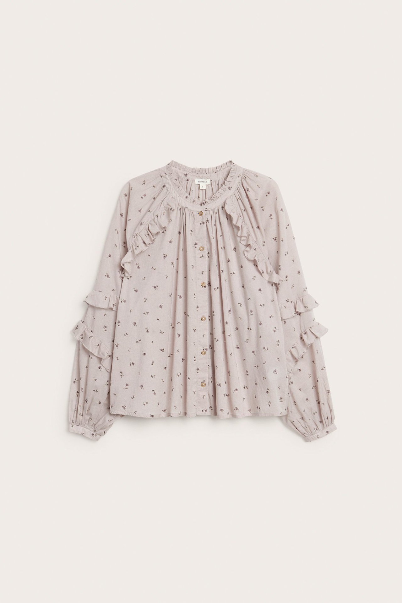 Vorderansicht einer helllila Damen-Baumwollbluse mit kleinem Blumenmuster, Rüschen und Knopfleiste.