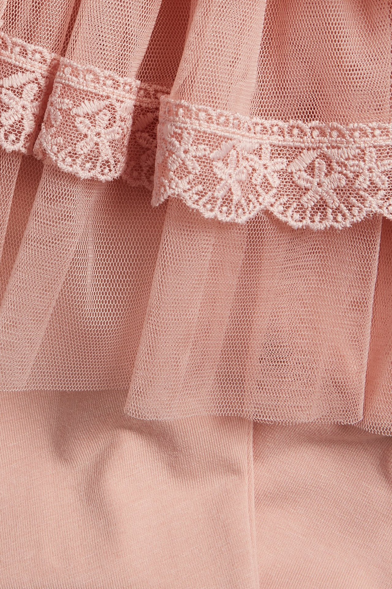 Nahaufnahme von rosa Baumwoll-Leggings mit angenähtem Rüschen-Tüllrock und Spitzenbesatz.