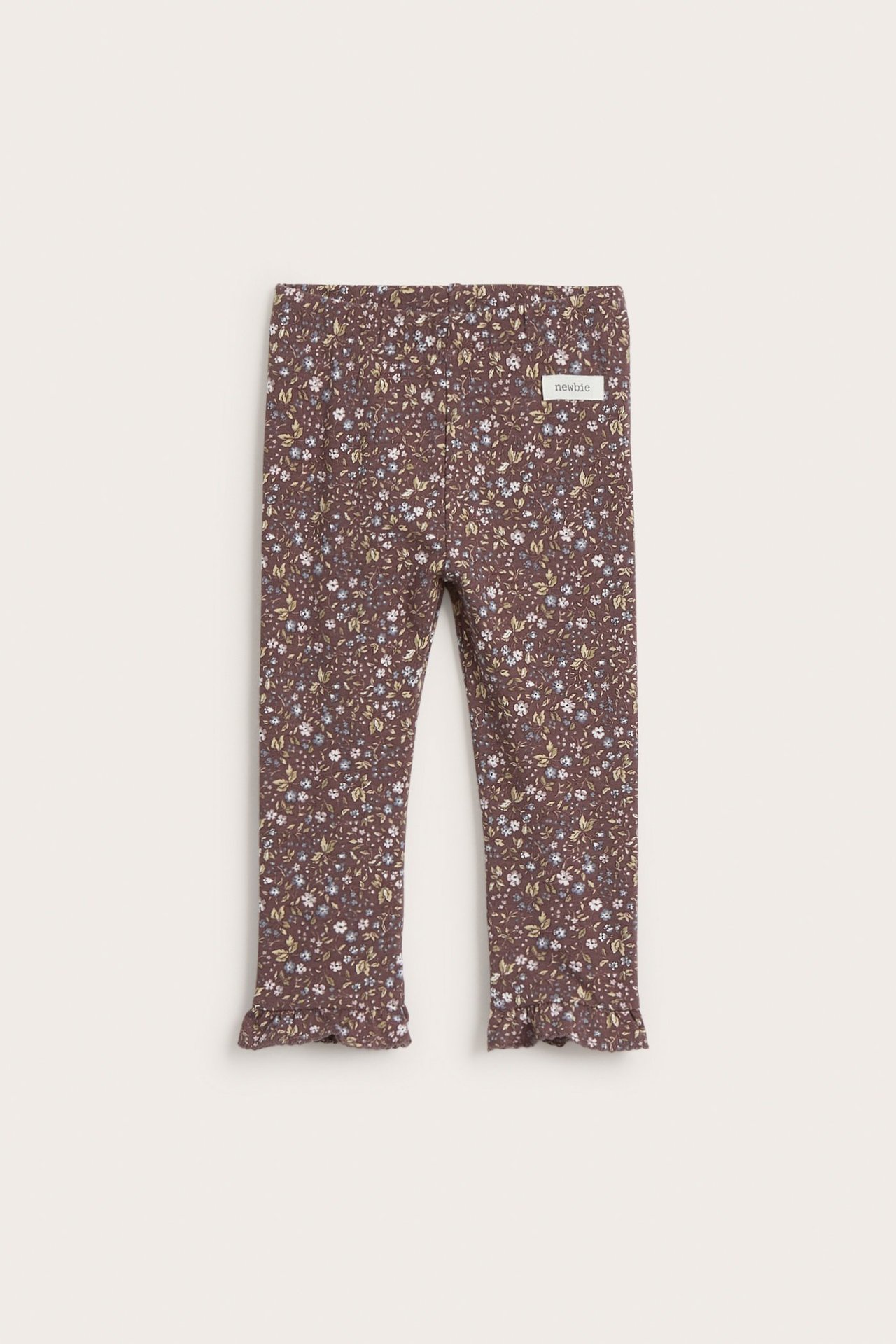 Vorderansicht: Lila florale Kinder-Leggings mit Gummibund und Rüschen an den Knöcheln.