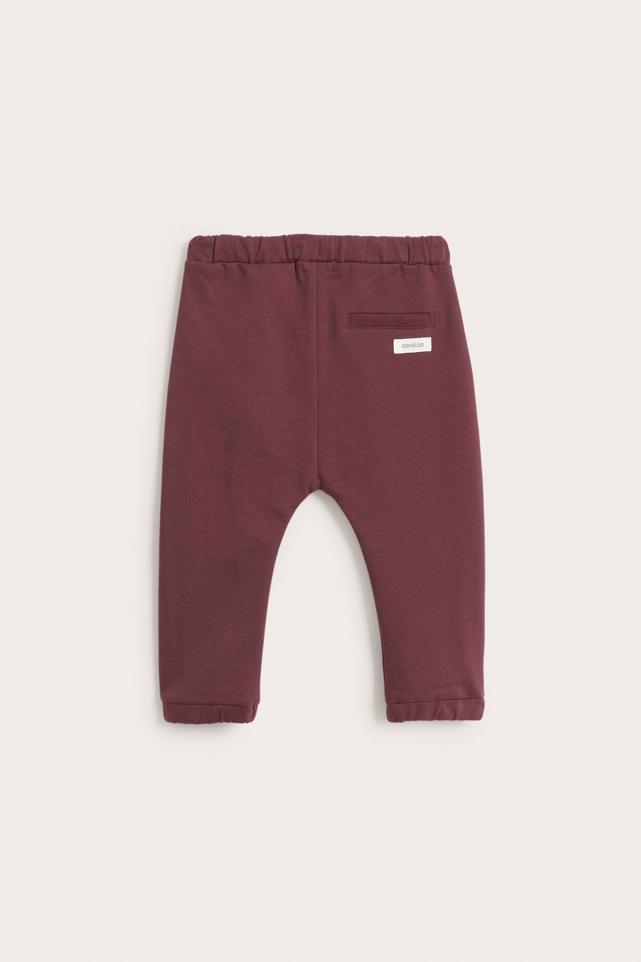 Back view of baby's wine red cotton jogging pants with elastic waist and ribbed decorative pocket.