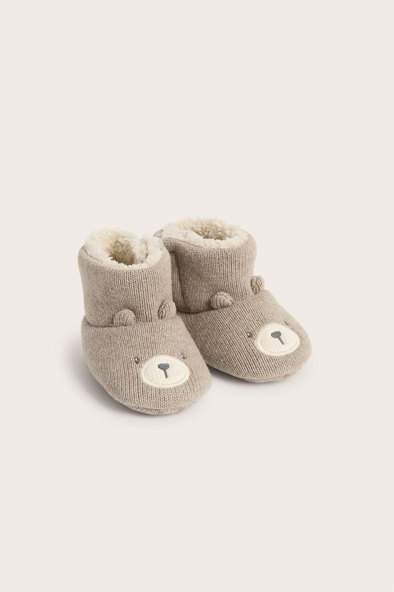 Front view of brown melange knitted baby booties with fluffy lining and embroidered bear faces.