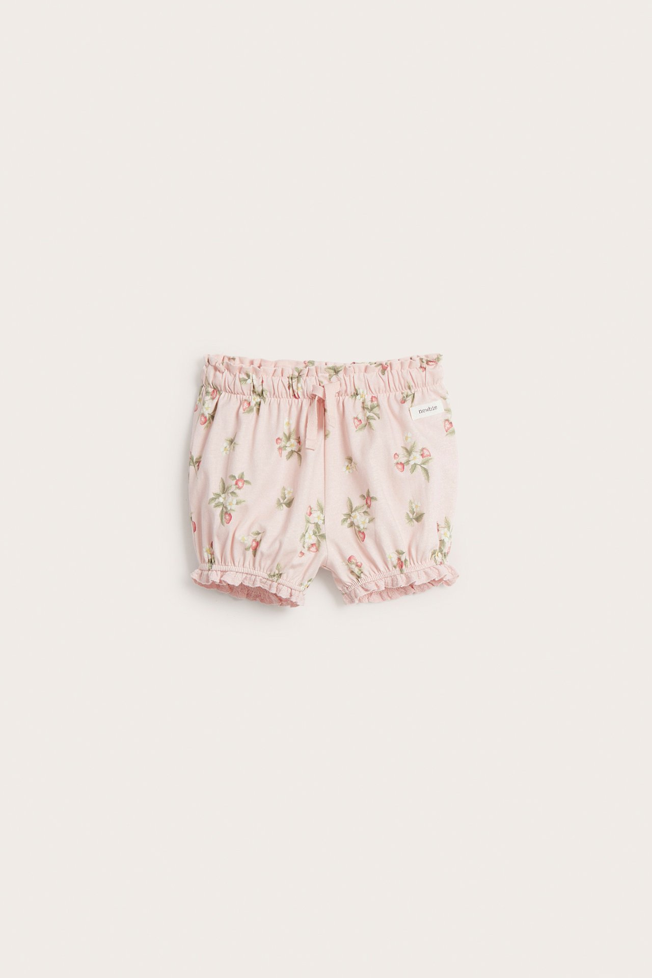 Front view of light pink baby shorts with strawberry pattern, elasticated waist, drawstring, and ruffled leg openings.