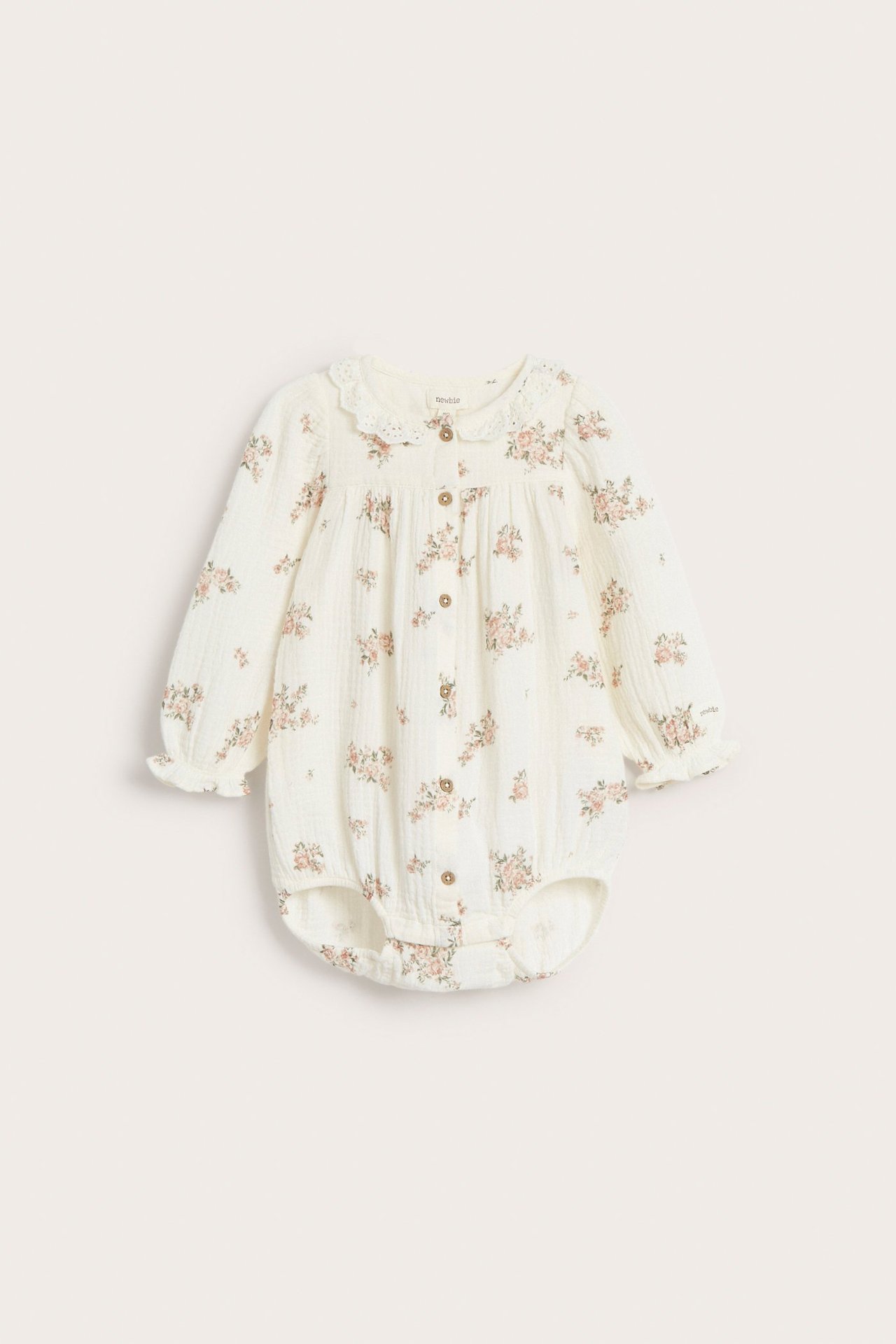 Vorderansicht: Off-white Baby-Blusenbody mit Blumenmuster, Spitzenkragen, Knöpfen und langen Puffärmeln.