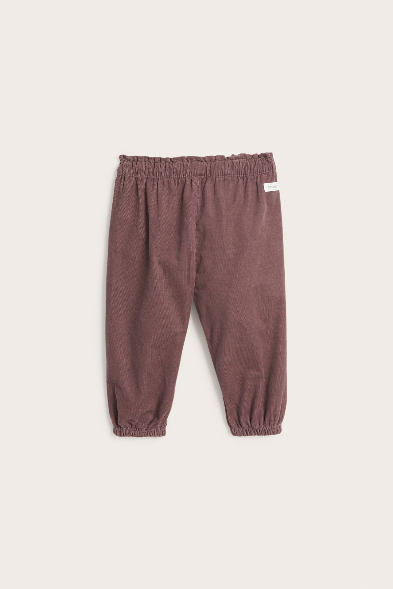 Front view of lilac corduroy trousers with an elasticated waist and gathered elastic cuffs.