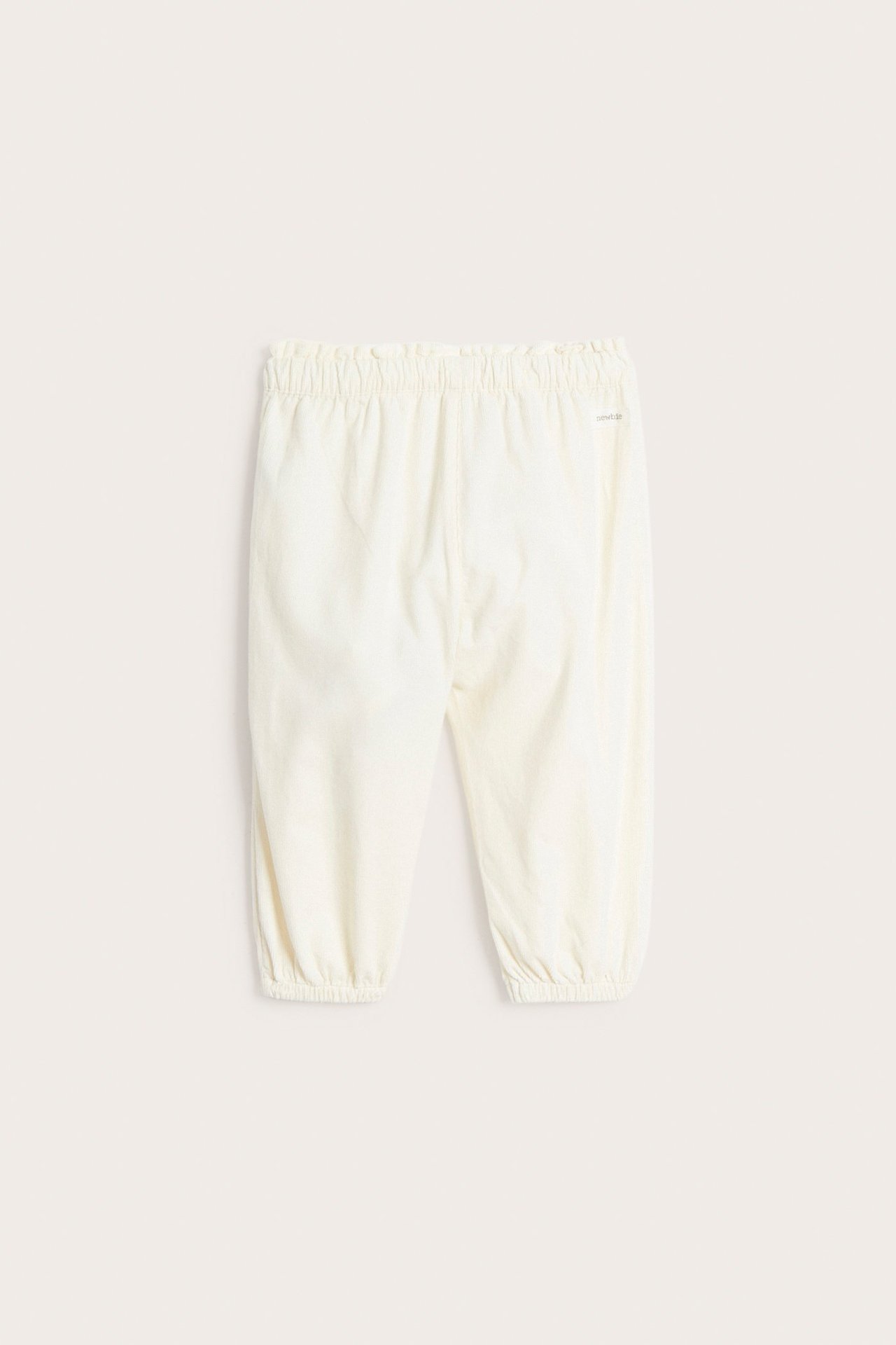 Rückansicht: Hellbeige Baby-Cordhose mit elastischem Bund und elastischen Beinabschlüssen.