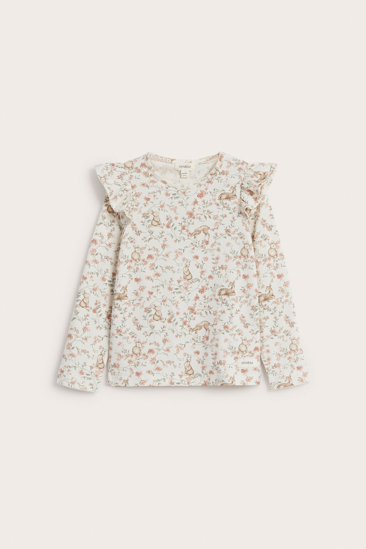 Front view of an off-white kid's long-sleeved top with a floral and animal print, featuring shoulder ruffles.