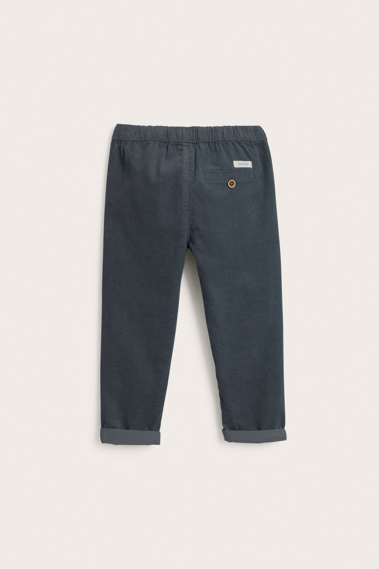Rückansicht: dunkelblaue Kinder-Cordhose mit elastischem Bund und umgeschlagenen Beinabschlüssen.