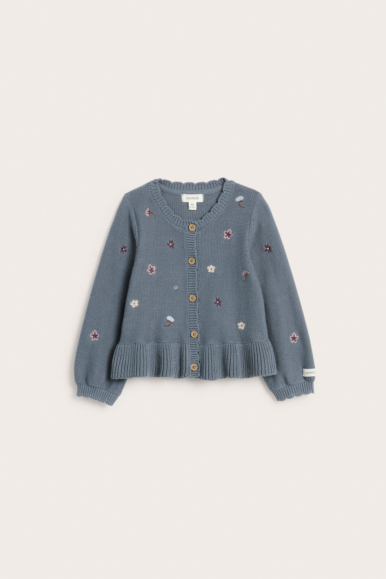 Vorderansicht einer blauen gestrickten Kinder-Baumwollstrickjacke mit Blumenstickereien, gerippten Kanten und Knöpfen.