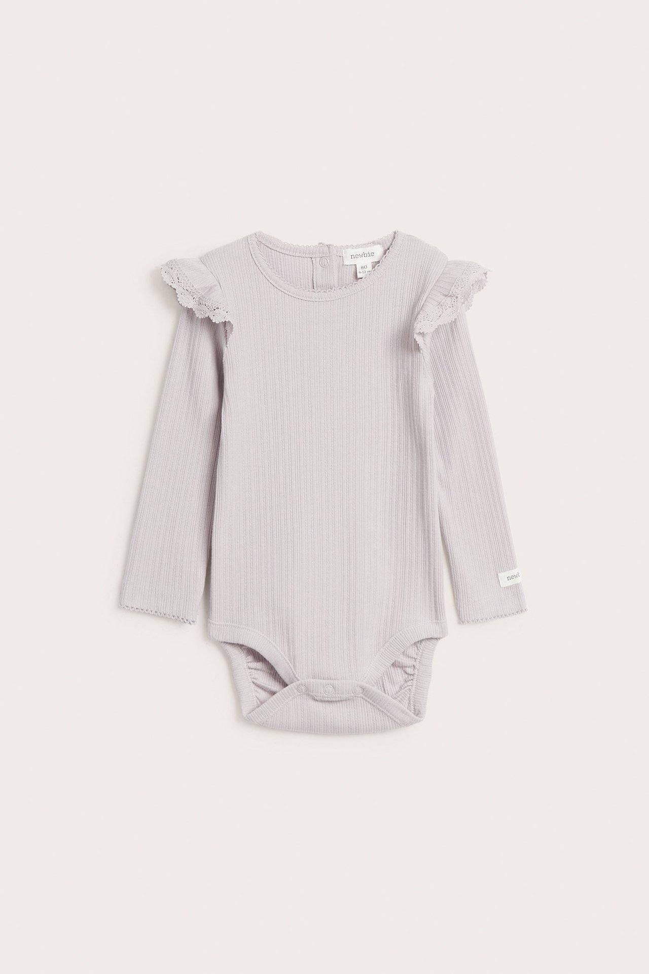 Front view of a light lilac ribbed baby bodysuit with long sleeves, lace-edged shoulder ruffles, and snap buttons.