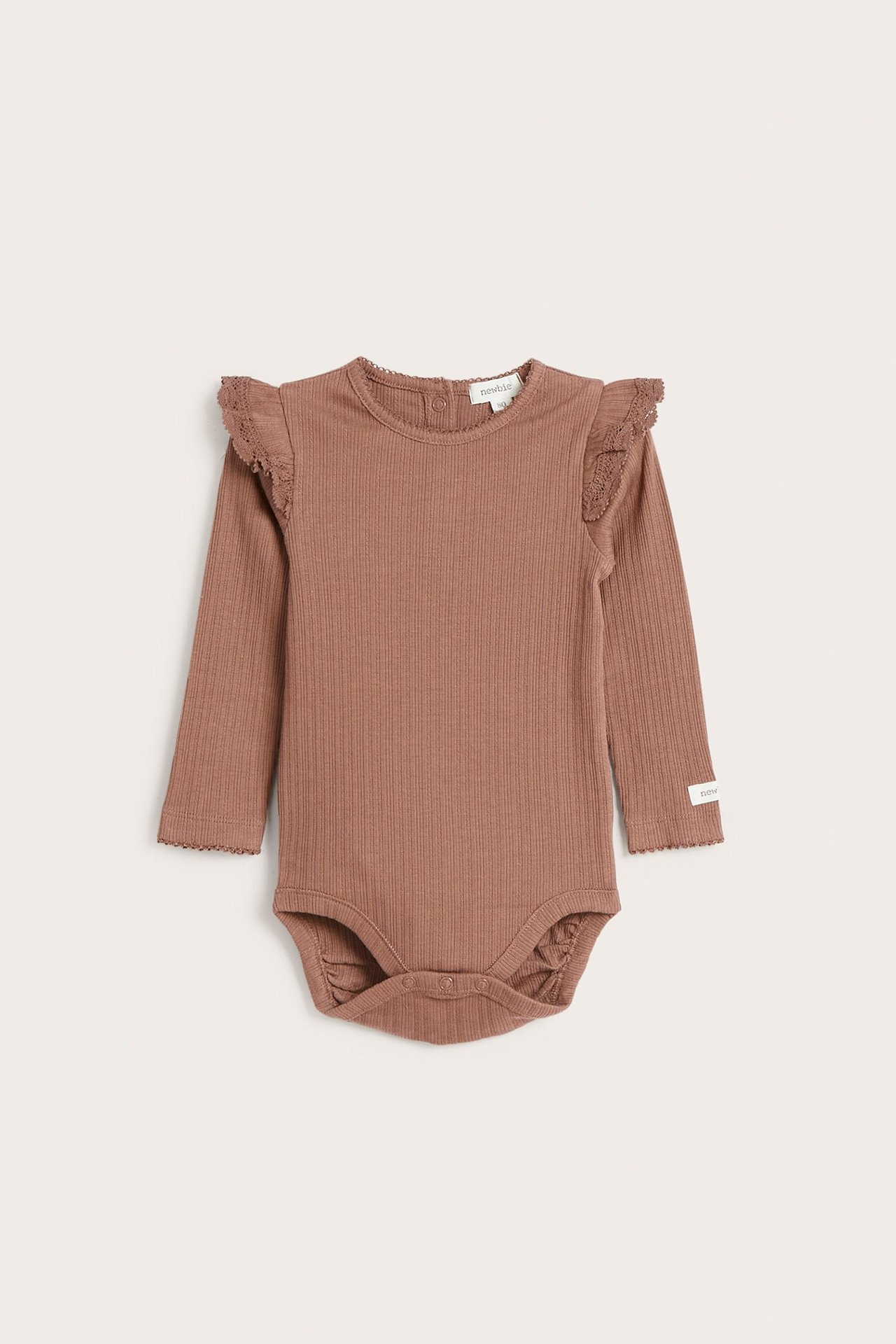 Vorderansicht eines dunkelrosa gerippten Baby-Bodys mit langen Ärmeln, Spitzenrüschen an den Schultern und Druckknöpfen.