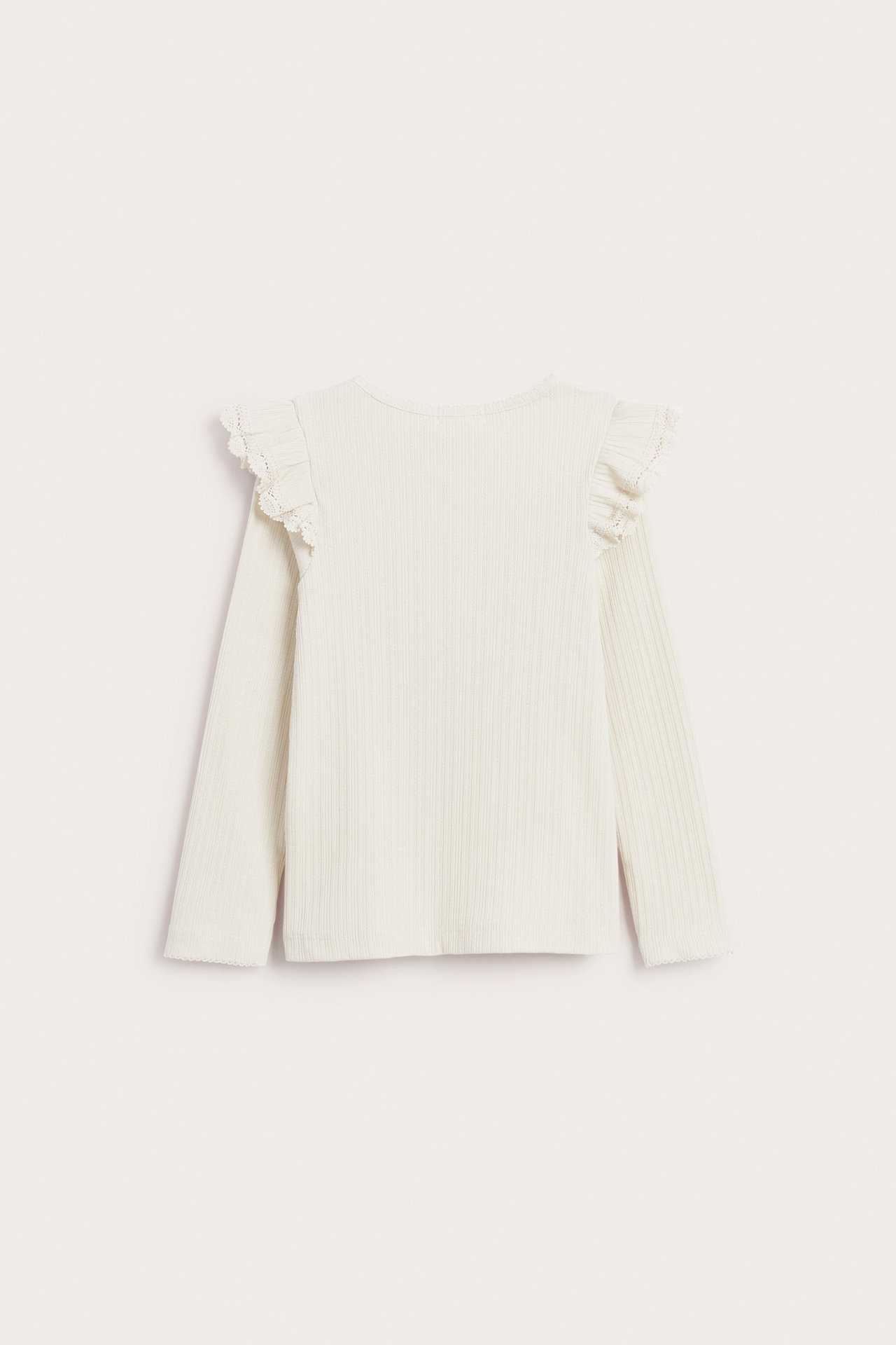 Back view of a white ribbed long-sleeve top with ruffled lace-trim shoulders.