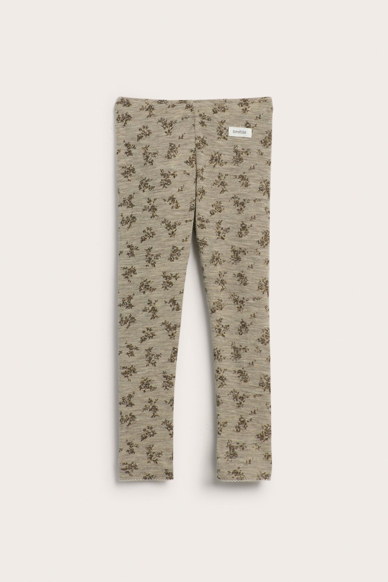 Front view of beige melange merino wool leggings with a dark floral pattern and elastic waist.