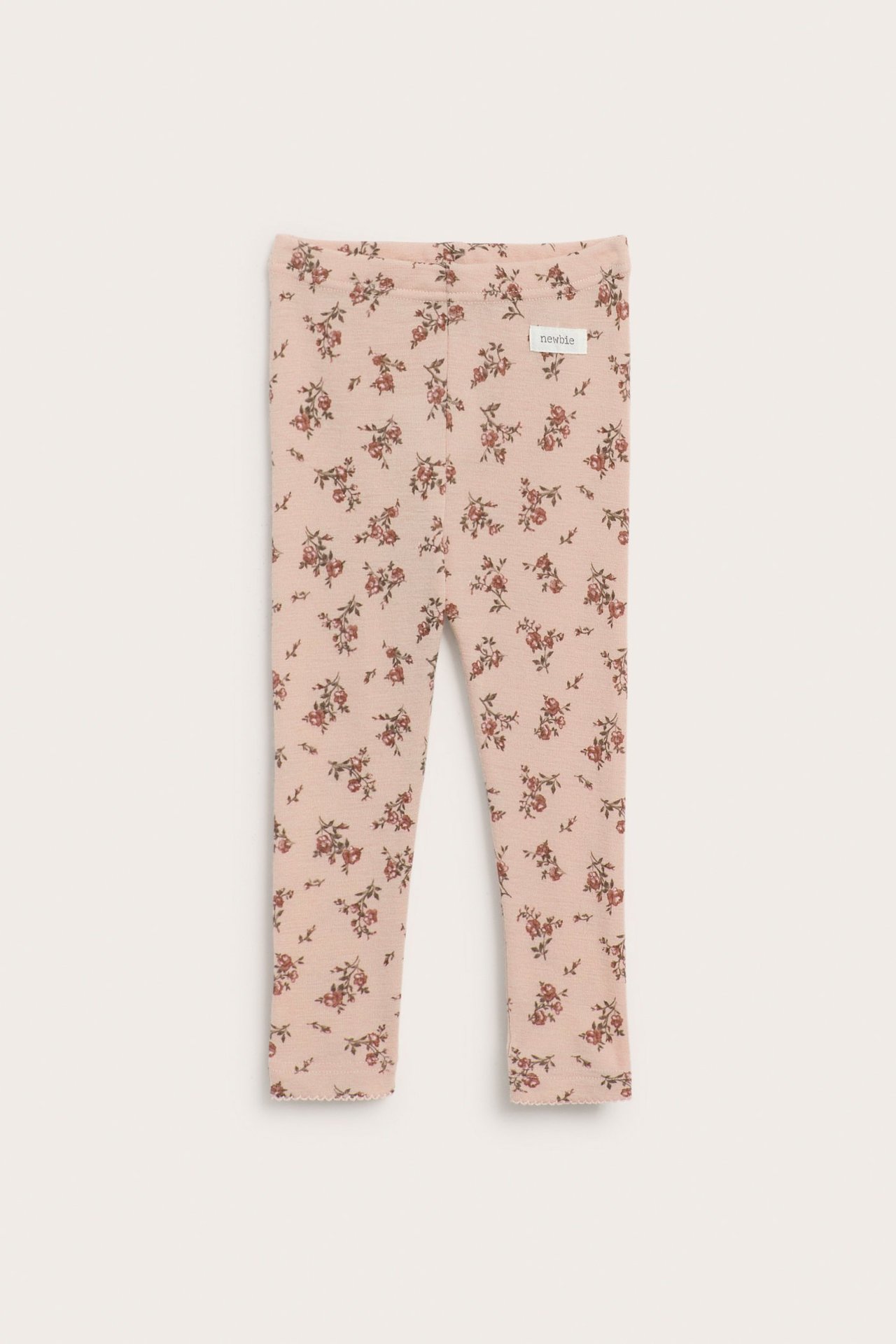 Vorderansicht: Baby-Leggings aus rosa Merinowolle mit Blumenmuster, Gummibund und Picot-Saum.