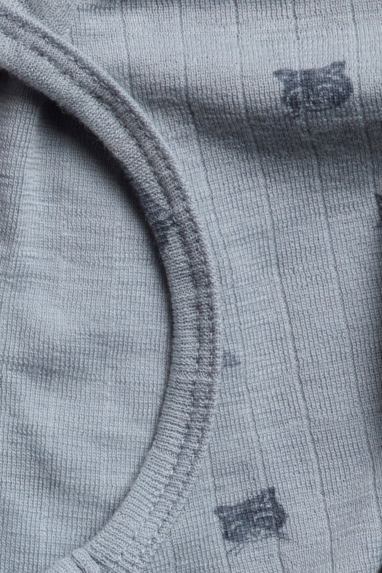 Nahaufnahme einer hellblauen Woll-Balaclava mit Rippenstruktur und dunklen Tiermustern.