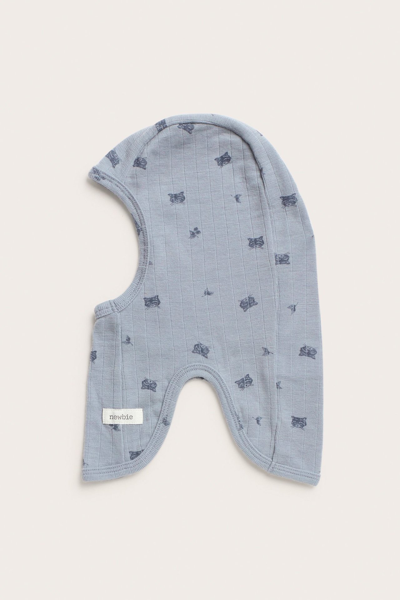 Vorderansicht einer hellblauen gerippten Woll-Balaclava mit dunklen Tiermustern.
