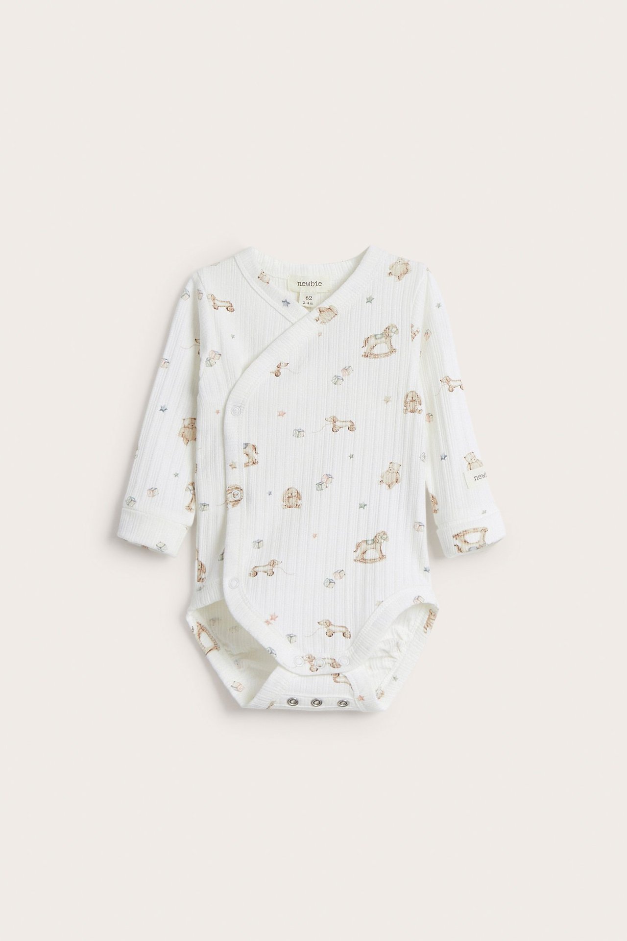 Front view of an off-white baby long-sleeved wrap bodysuit with a toy pattern and snap buttons.