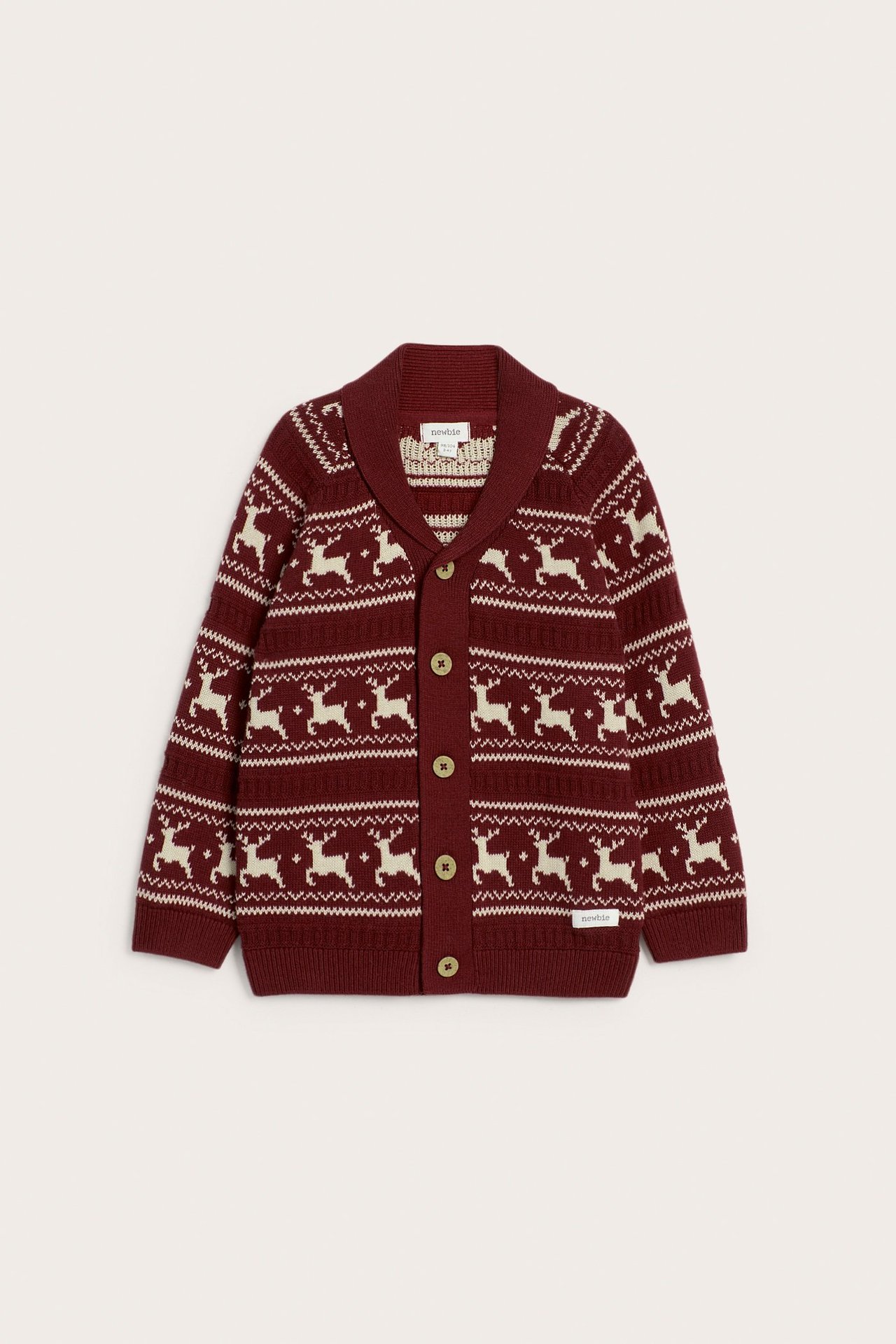 Front view of a kid's red jacquard-knitted cotton cardigan with white reindeer pattern, shawl collar.